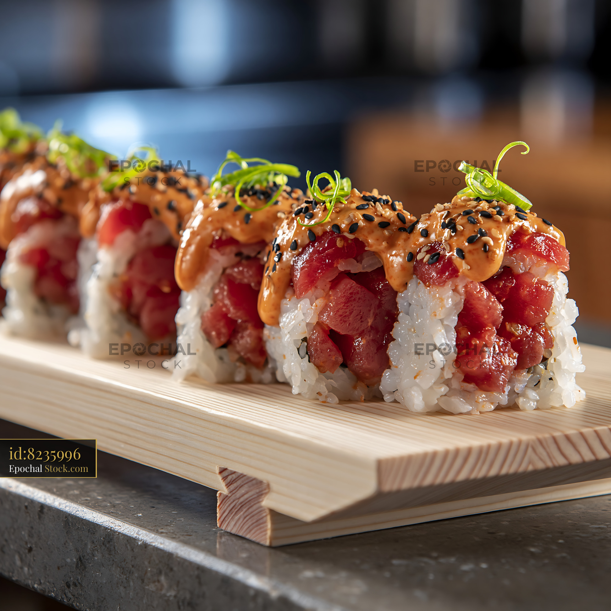 Spicy tuna sushi rolls with sriracha mayo on a wooden board - stock photo
