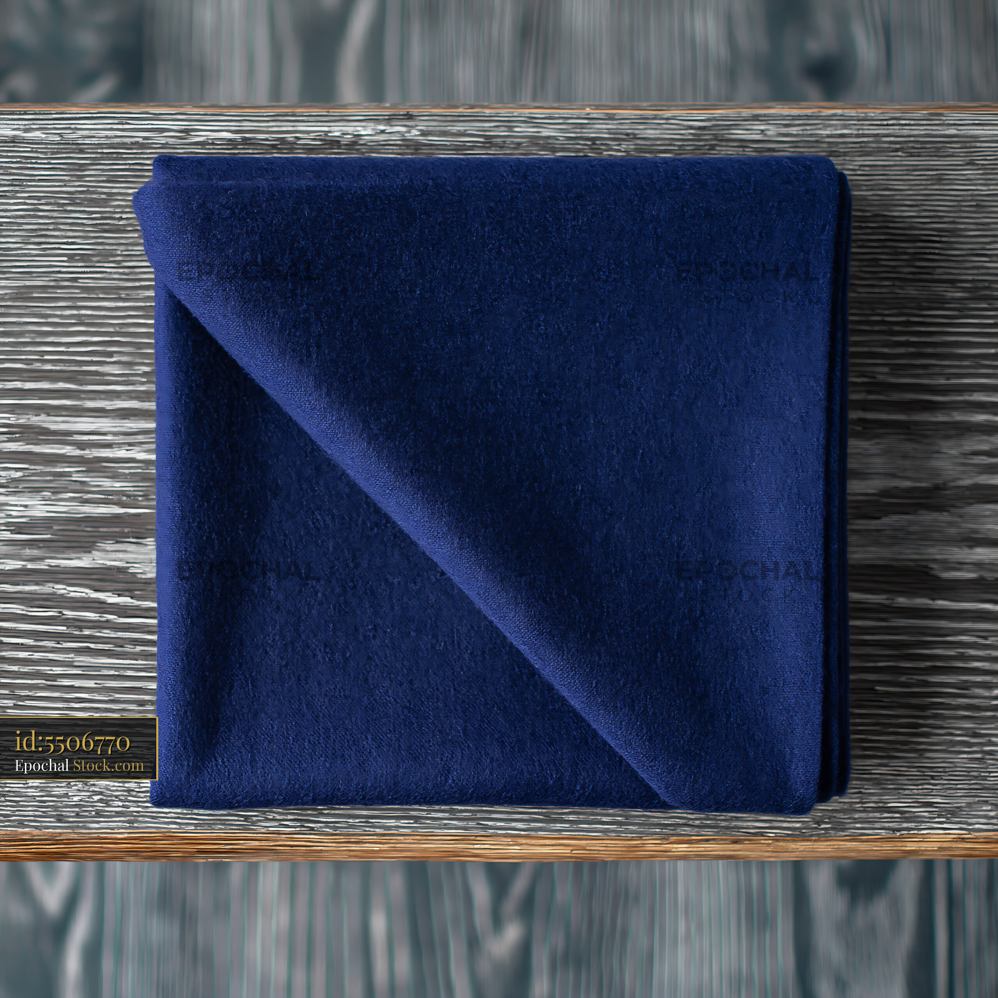 Navy blue fleece blanket folded on a weathered wooden garden bench - stock photo