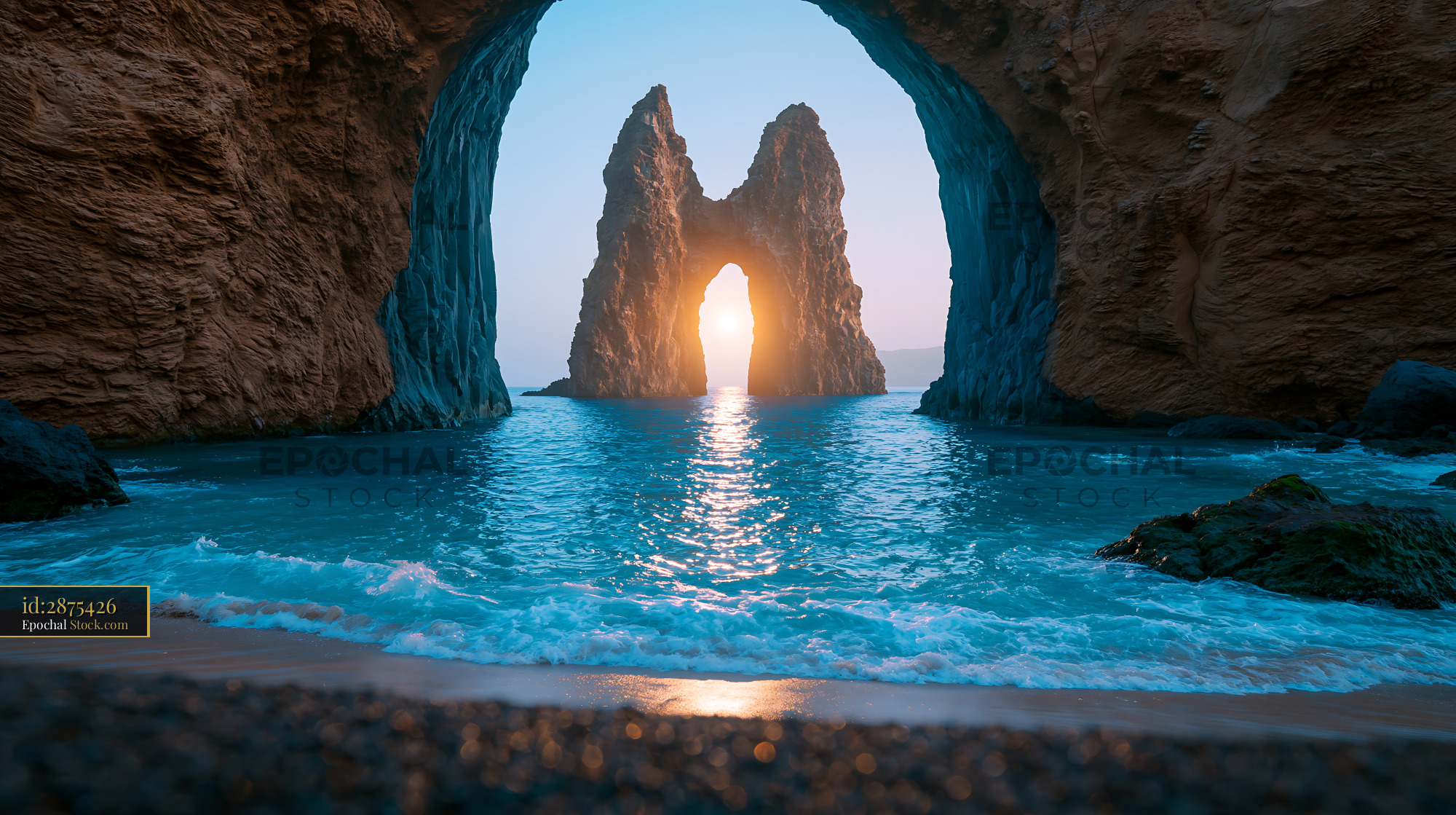 Sunlight glowing through a coastal rock arch on a black sand beach - stock photo