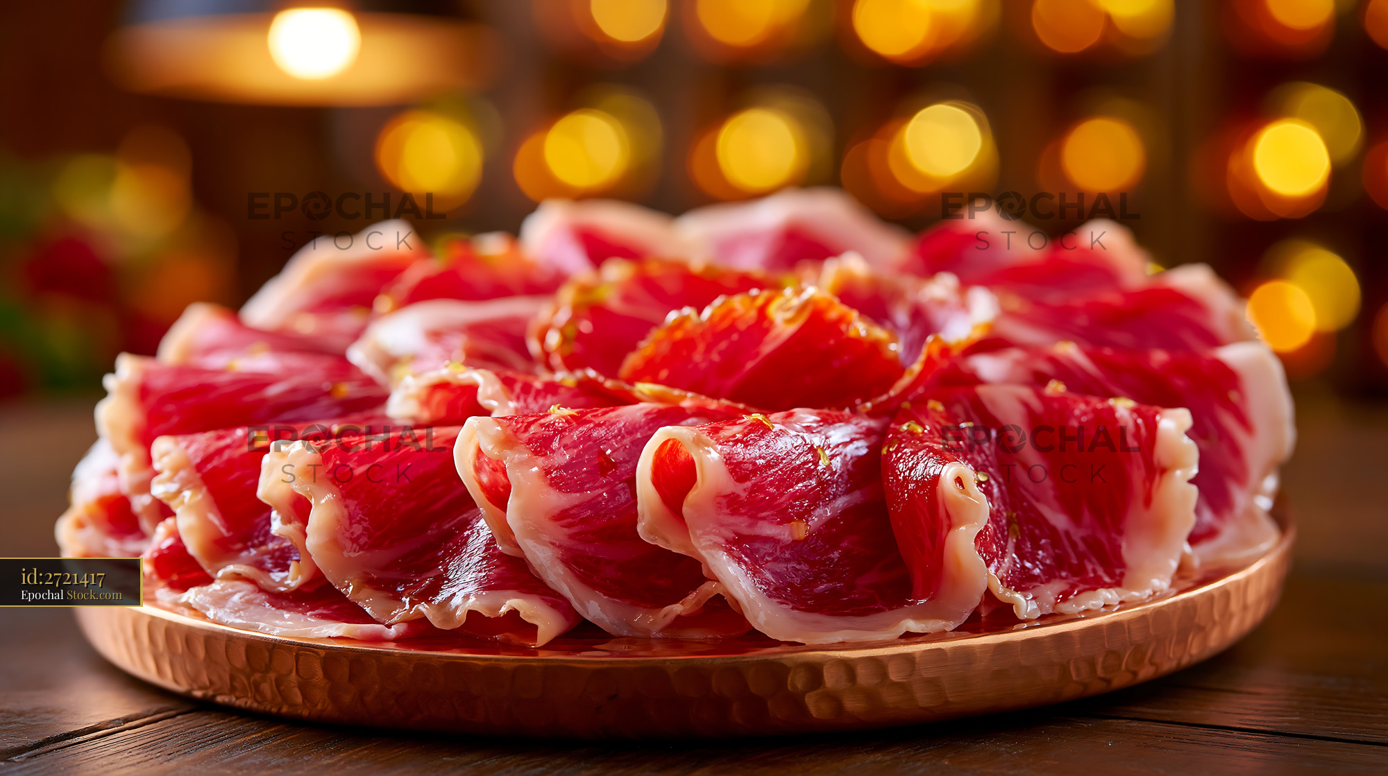Slices of premium jamon iberico de bellota meat on a copper platter - stock photo