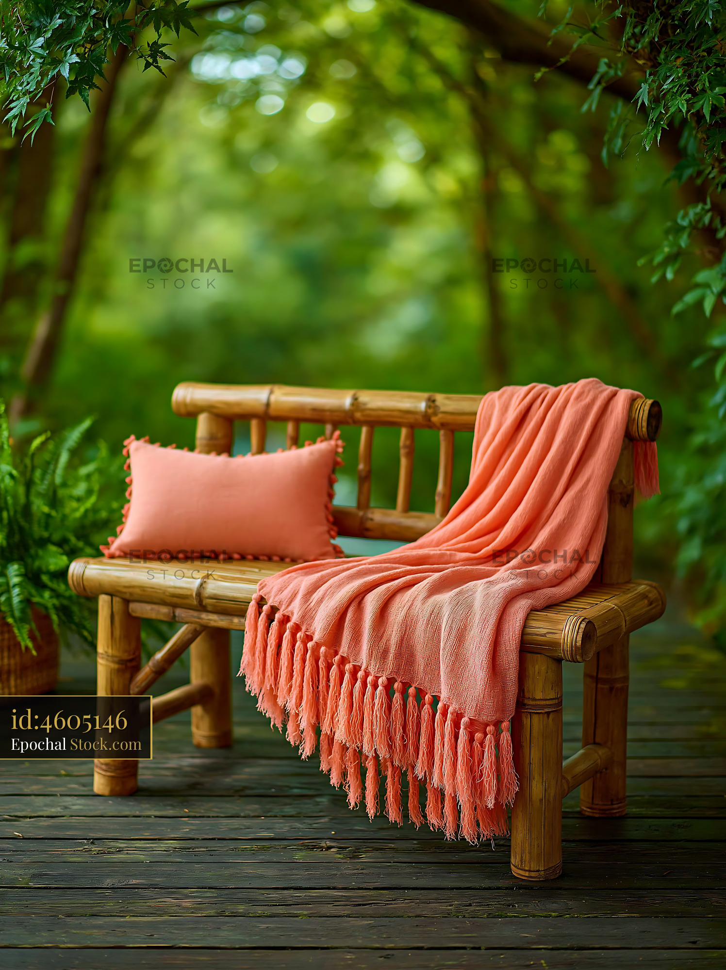 Bamboo garden bench with coral striped throw and pillow in a forest