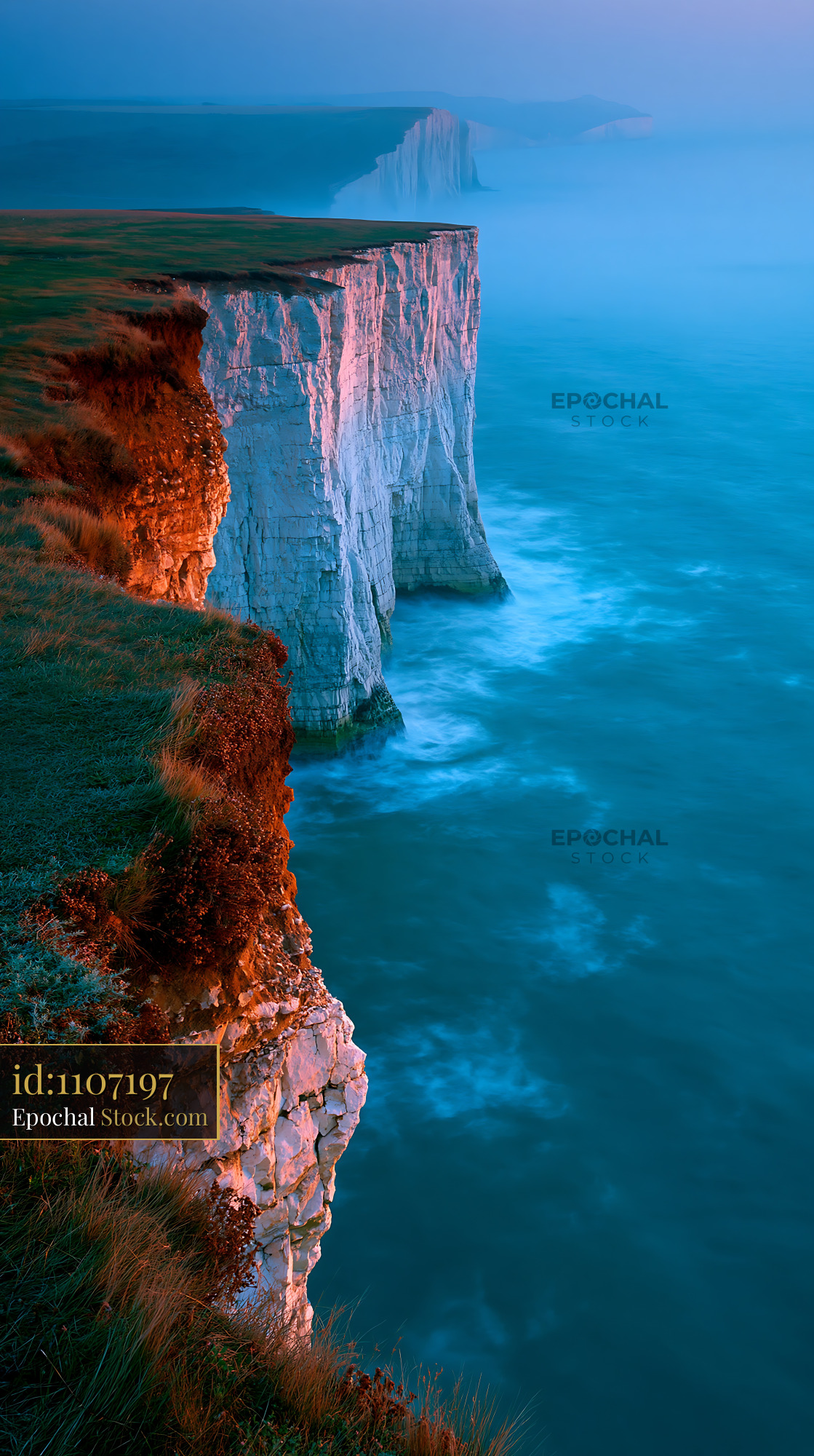 Majestic white chalk cliffs at sunrise with pink cliff coast glow - stock photo