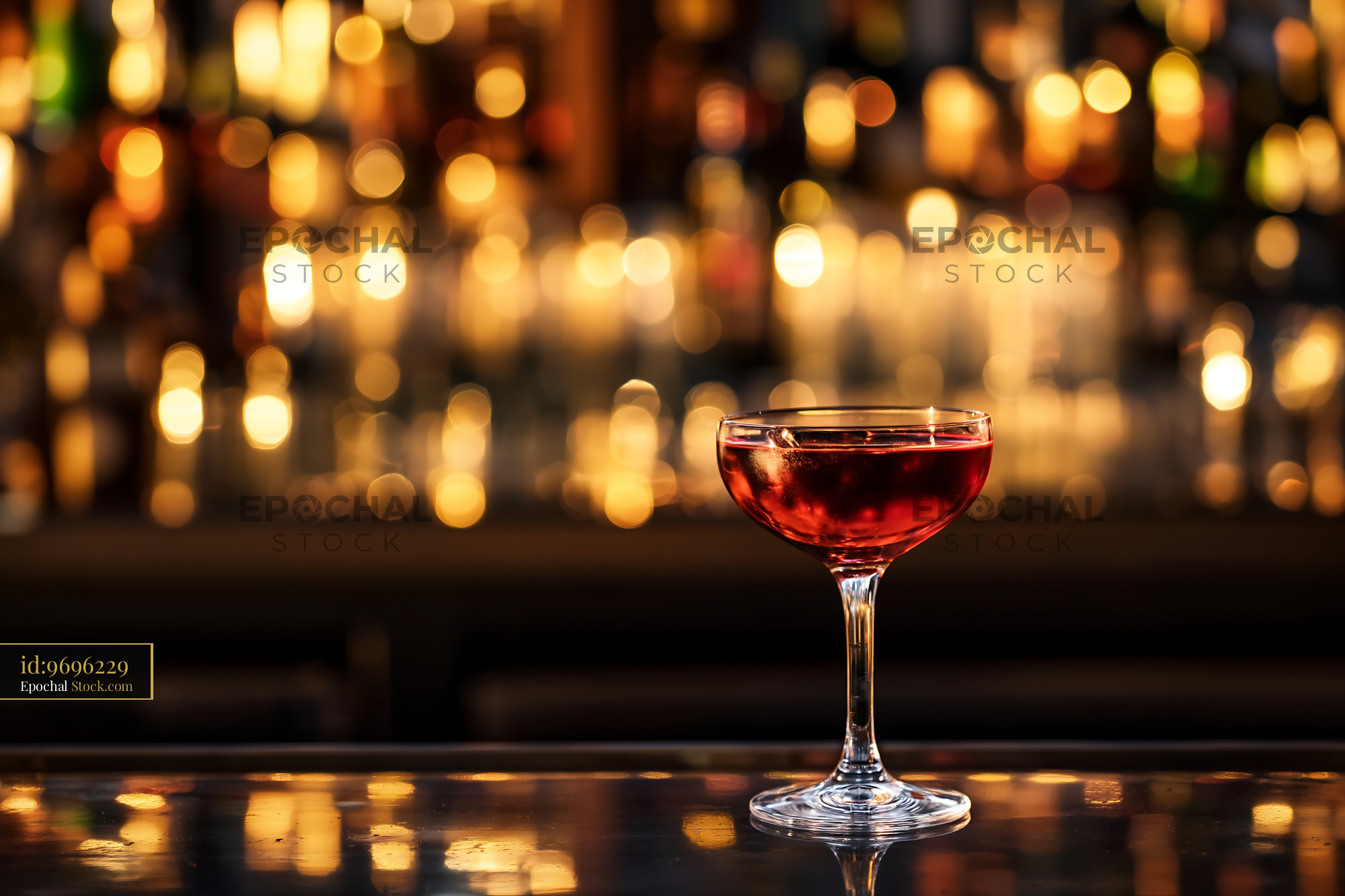 Red Cocktail Coupe Glass on Bar with Bokeh Lights - stock photo