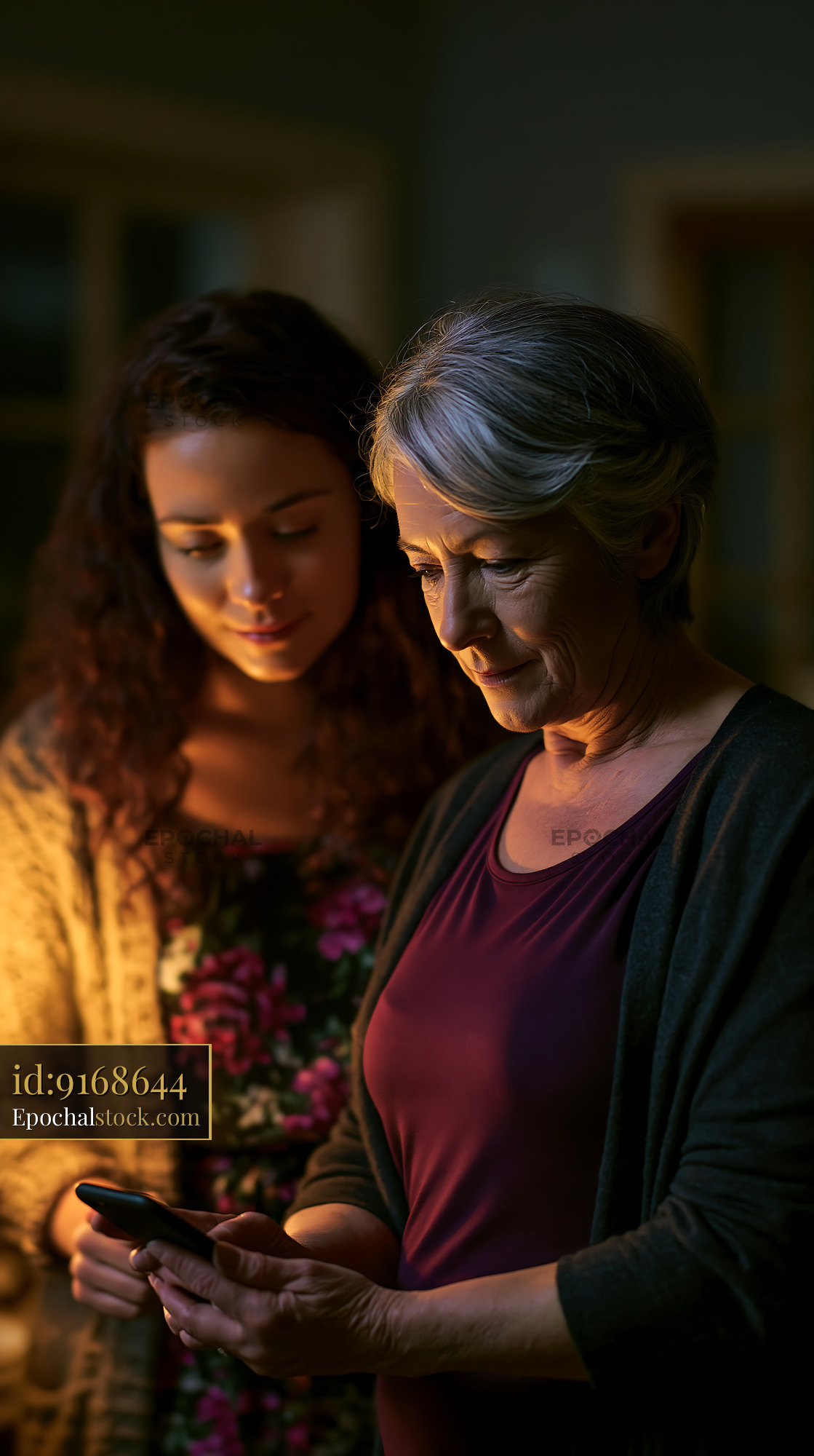 Watermarked full-resolution preview of Women sharing a moment while looking at a smartphone in a dim room