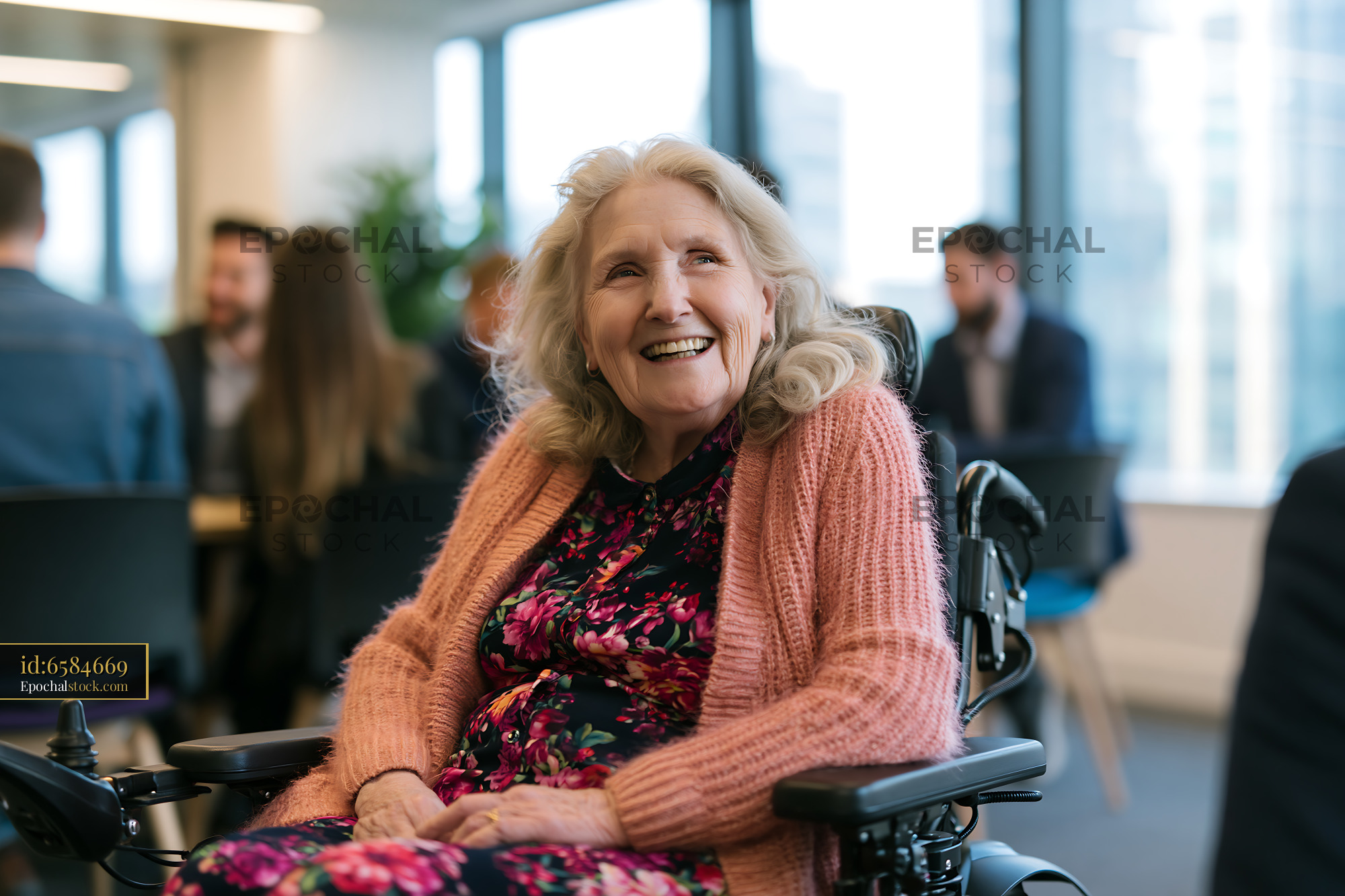 Watermarked full-resolution preview of Smiling woman in wheelchair during group meeting in bright office