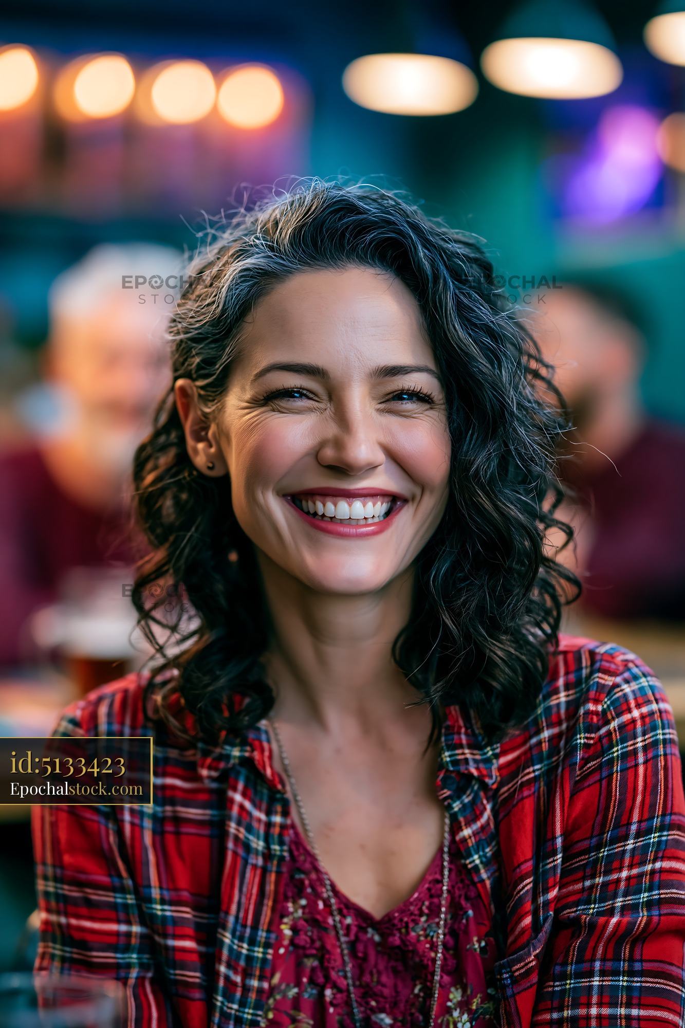 Watermarked full-resolution preview of Smiling woman in plaid shirt inside busy cafe