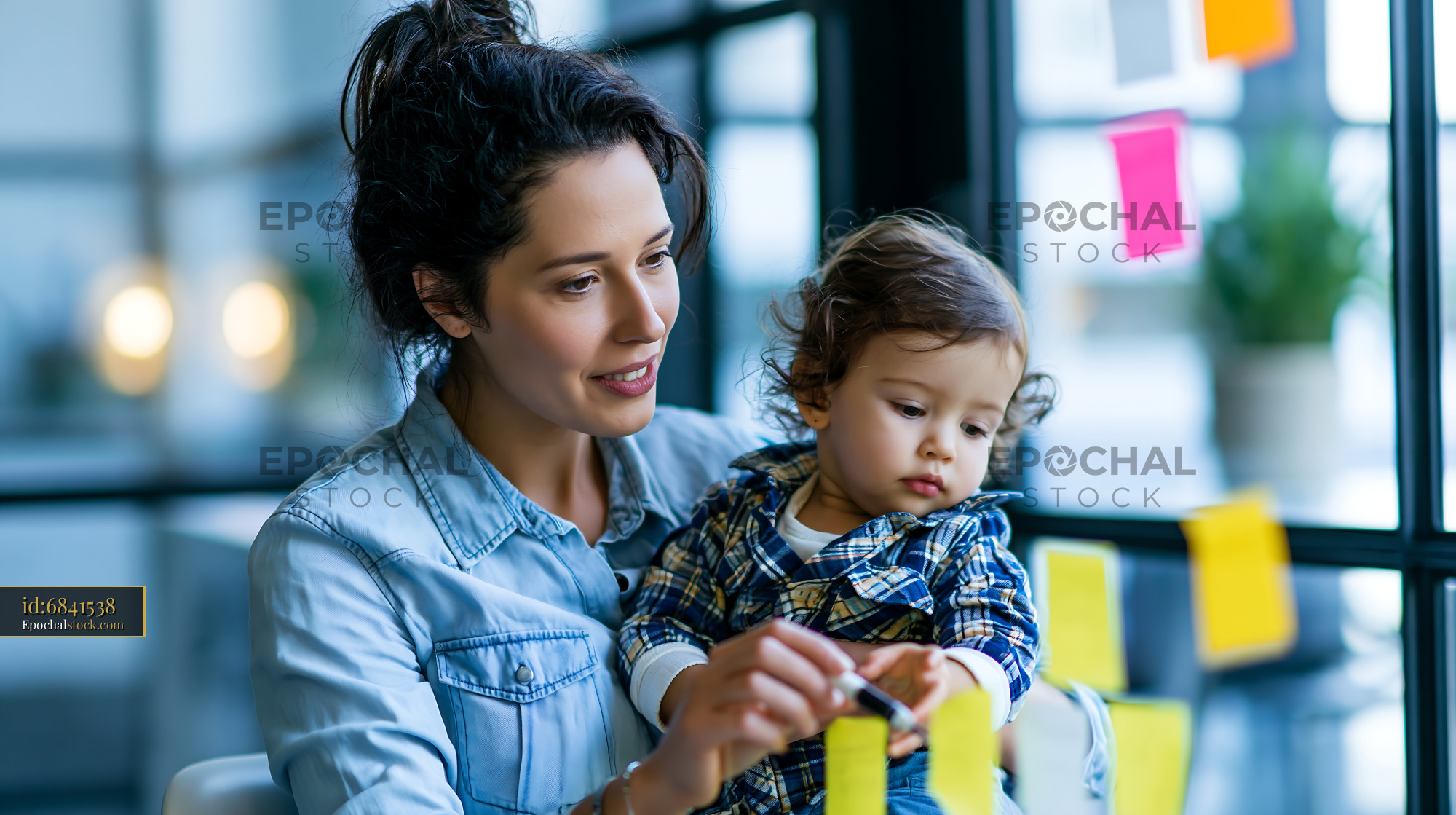 Watermarked full-resolution preview of Mother and child engaged in creative activity at a workspace