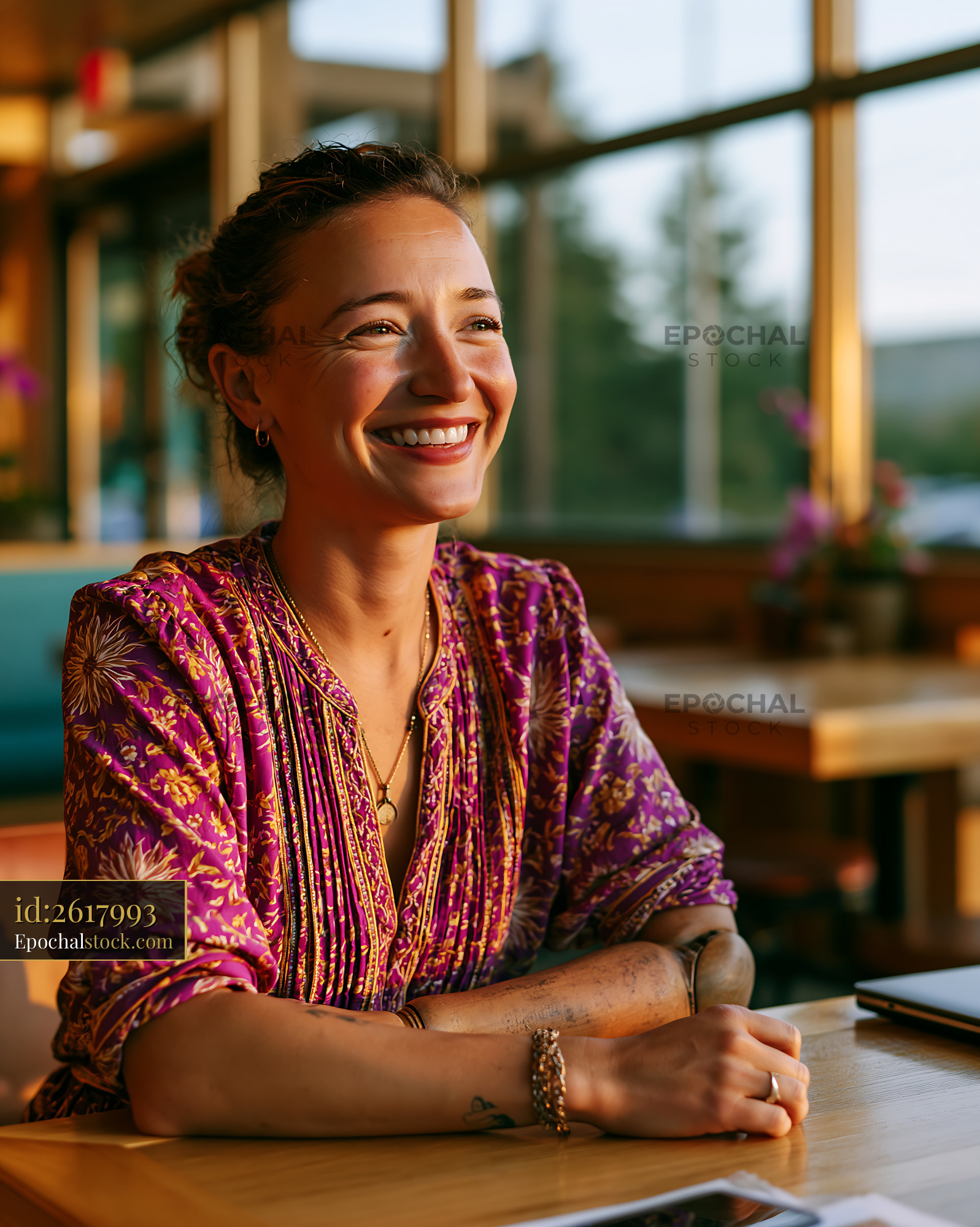 Watermarked full-resolution preview of Woman smiling at a cafe during golden hour