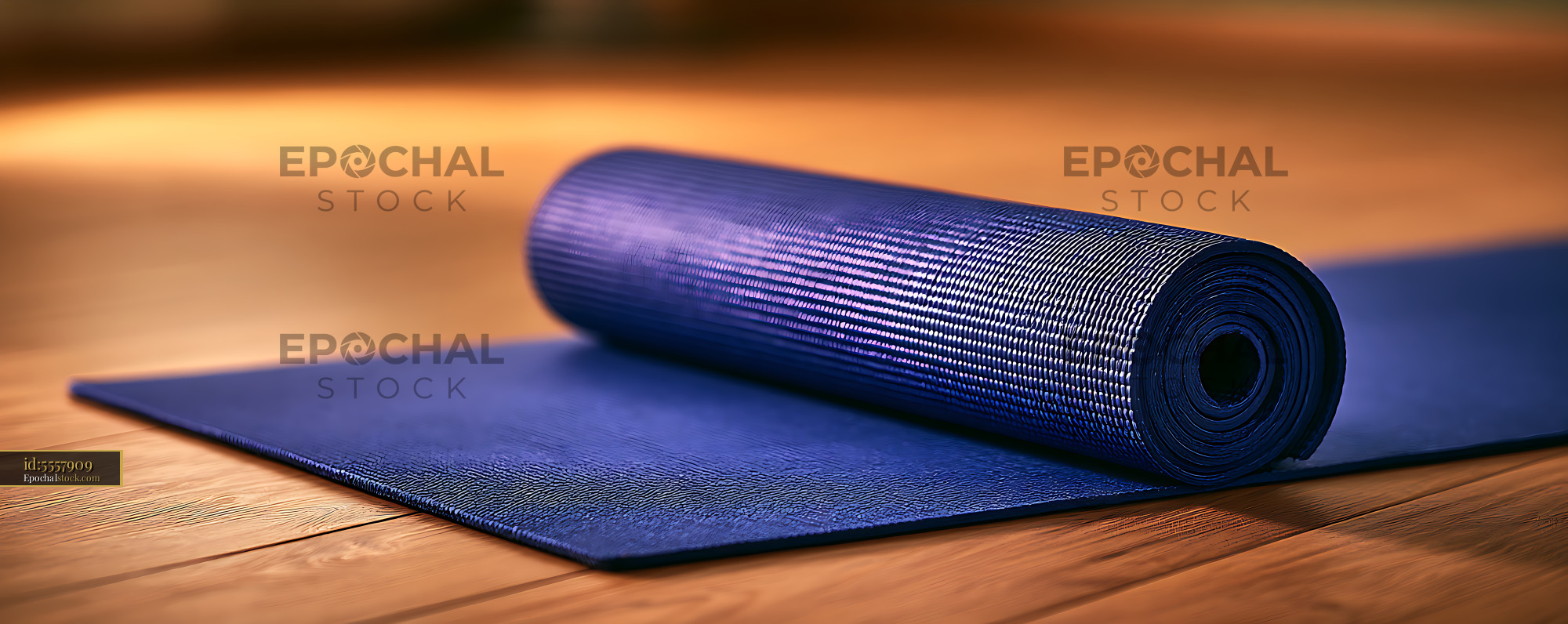 Watermarked full-resolution preview of Blue rolled workout mat in warm indoor light