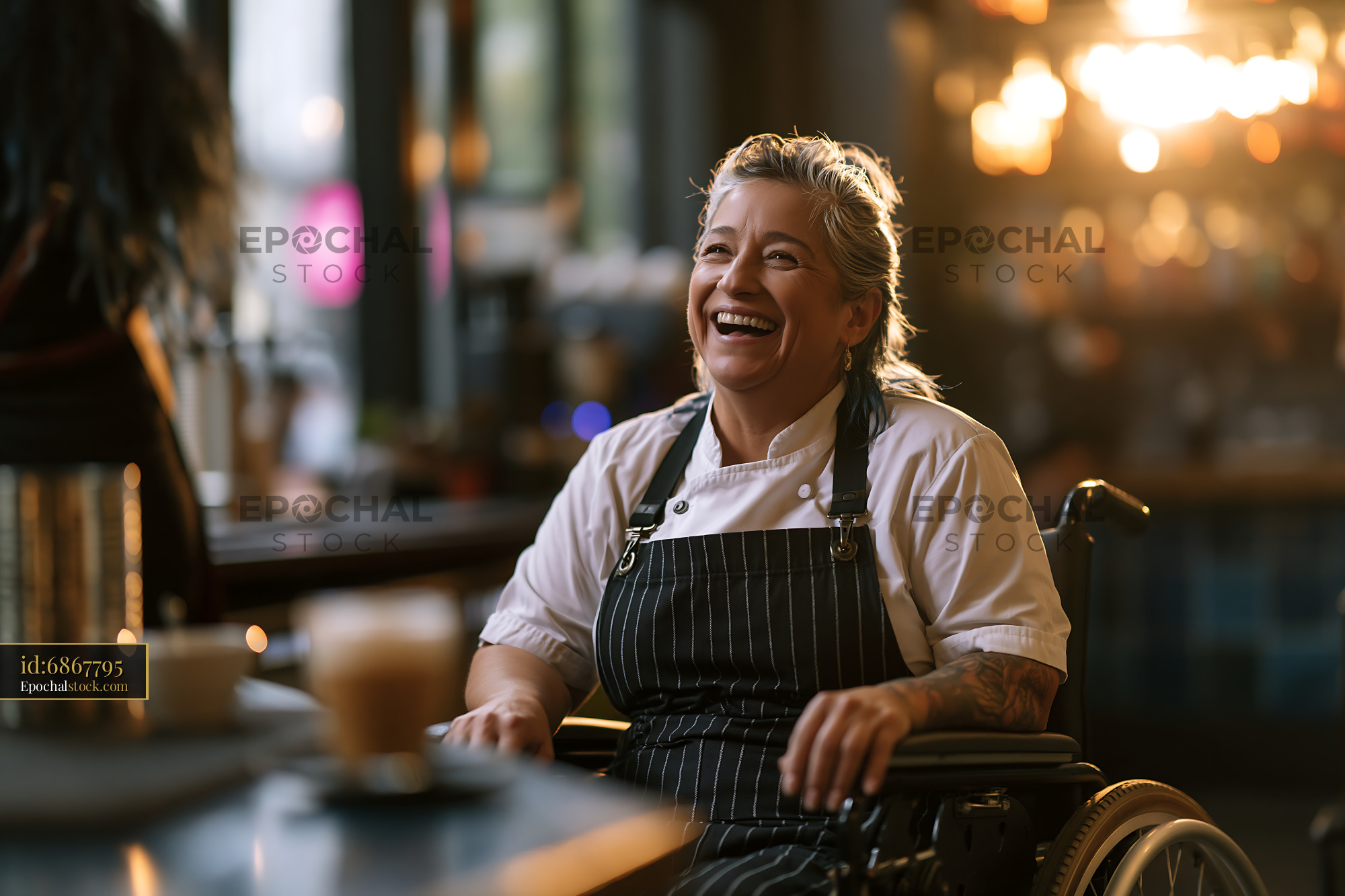 Watermarked full-resolution preview of Chef in a wheelchair smiles while working in a restaurant kitchen