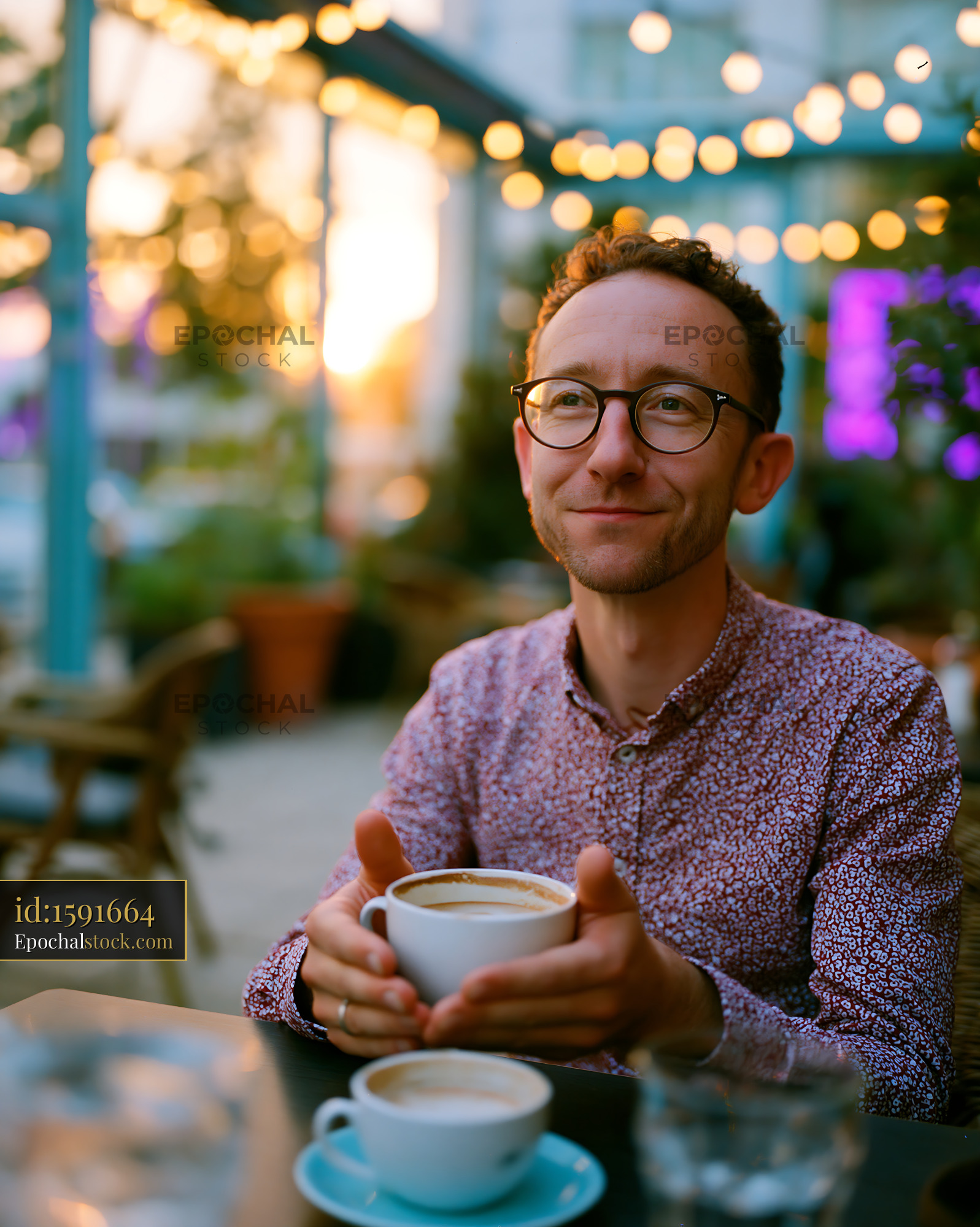 Watermarked full-resolution preview of Man enjoying coffee at outdoor cafe during sunset