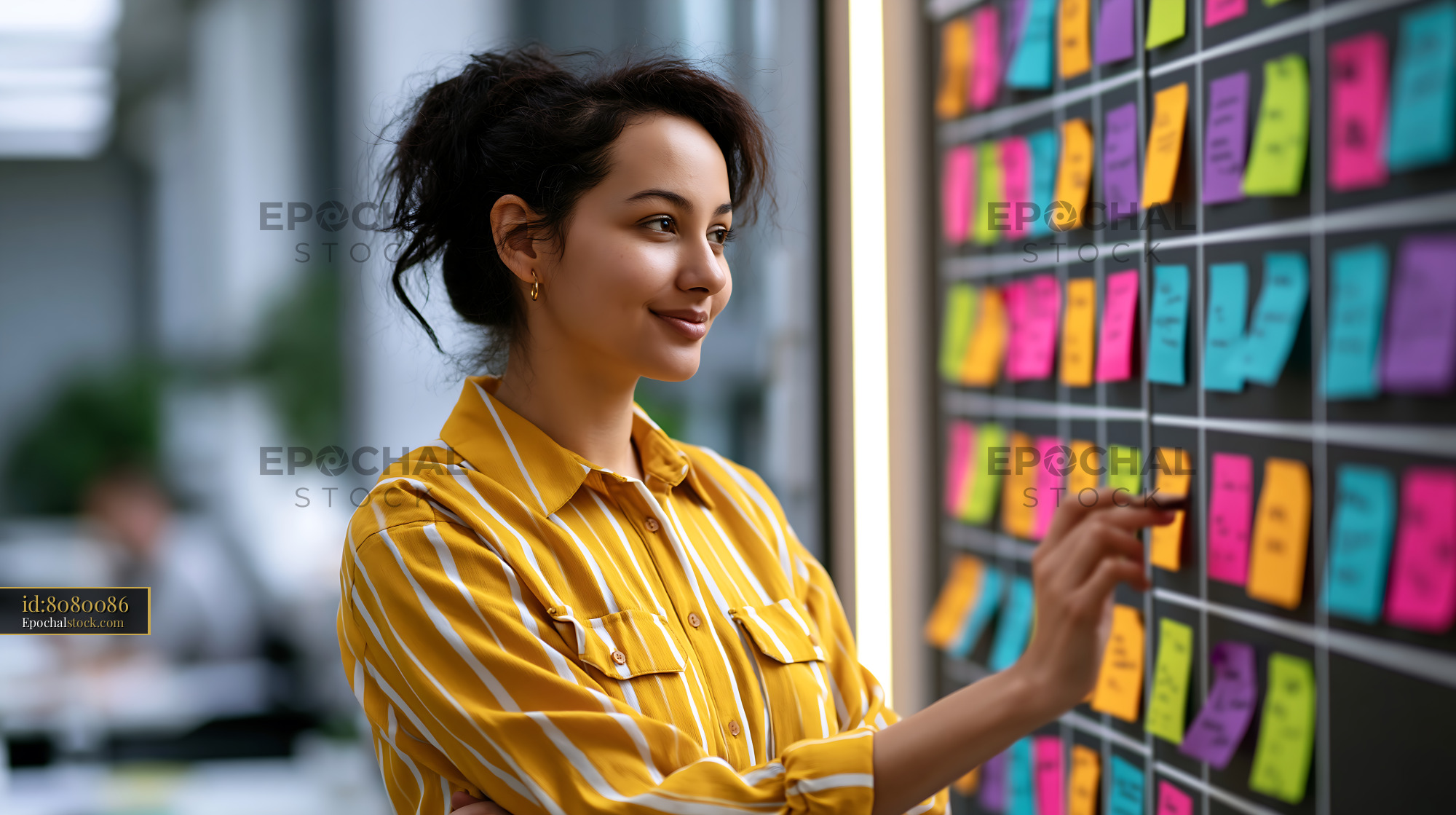 Watermarked full-resolution preview of Woman writing on sticky notes in an office