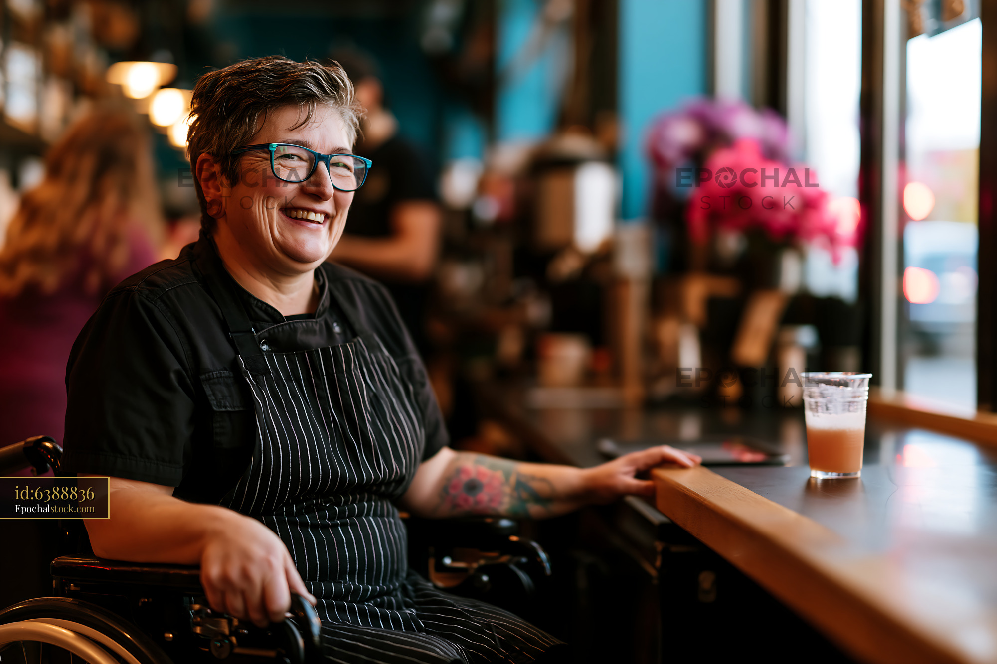 Watermarked full-resolution preview of Woman in wheelchair smiling at coffee shop counter
