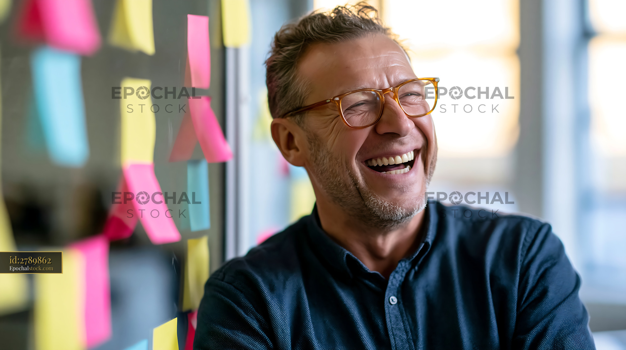 Watermarked full-resolution preview of Man laughing in an office setting with colorful sticky notes
