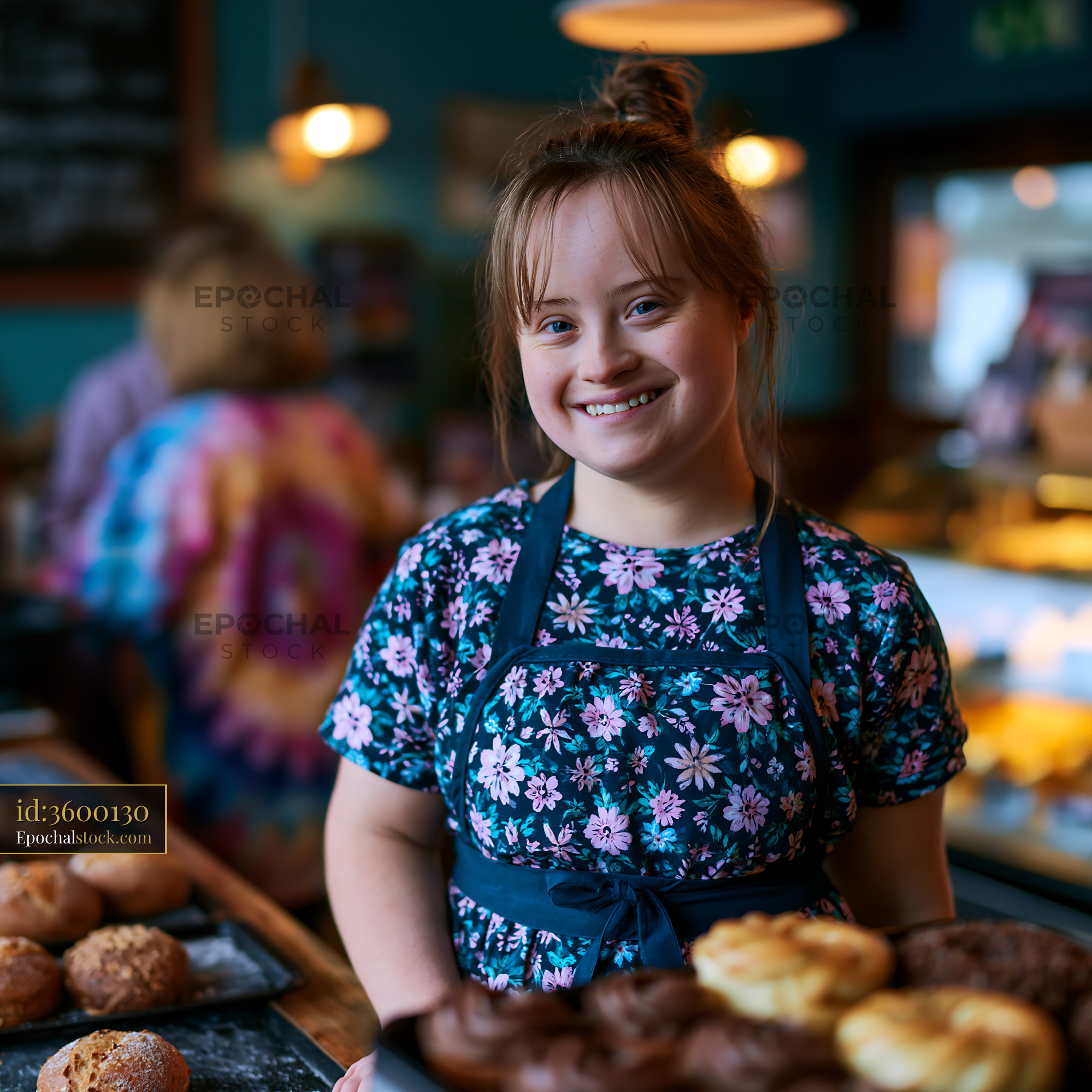 Watermarked full-resolution preview of Girl in apron holding baked goods at a cafe