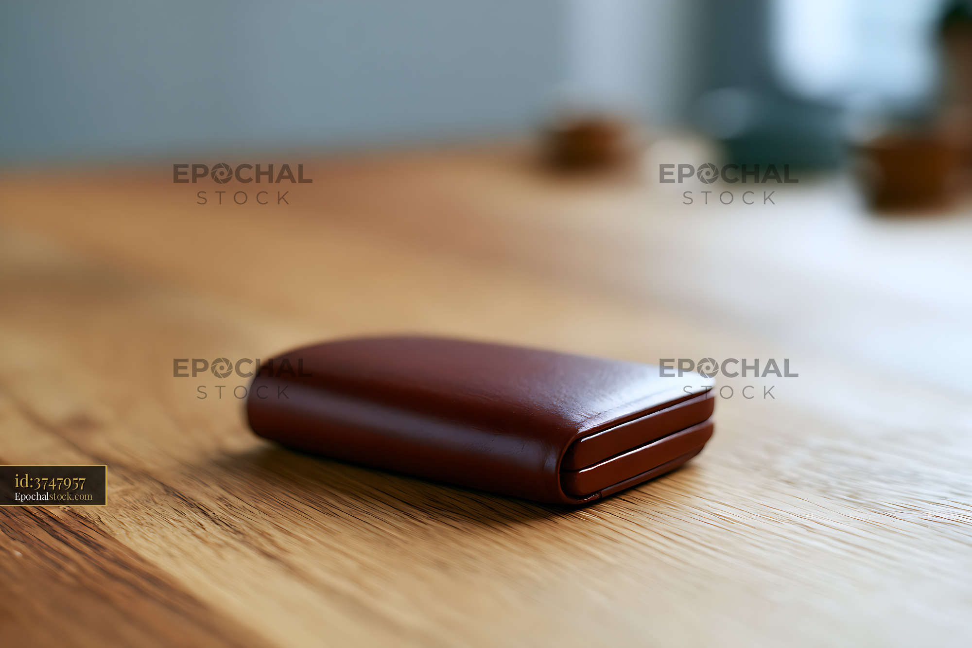 Watermarked full-resolution preview of Brown leather wallet resting on wood