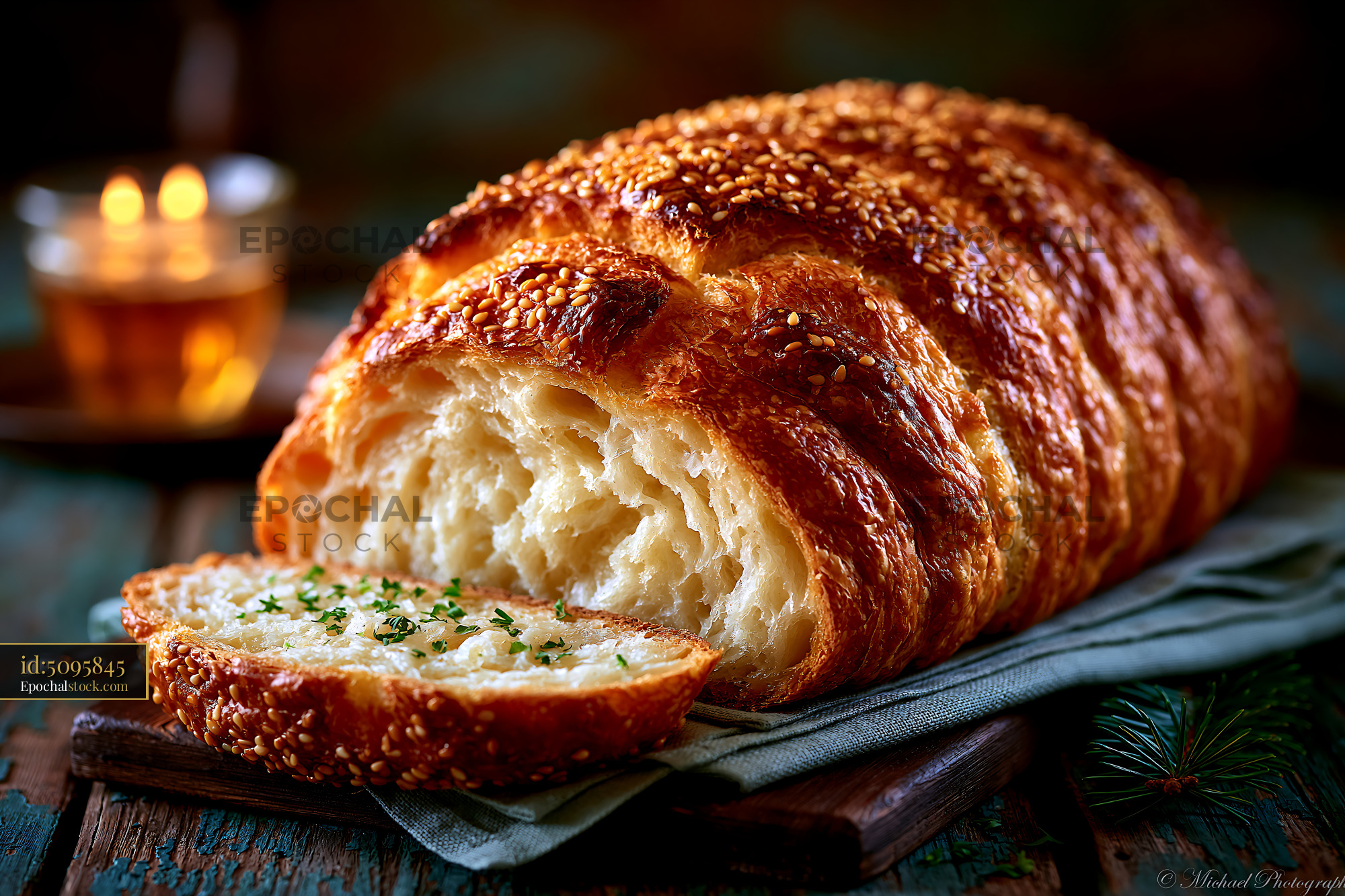 Watermarked full-resolution preview of Freshly baked sesame bread on a wooden table with soft lighting