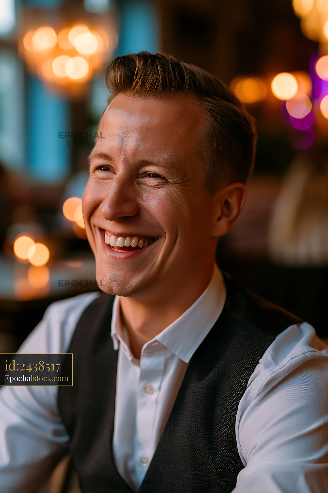 Watermarked full-resolution preview of Man smiling in casual setting with warm lights