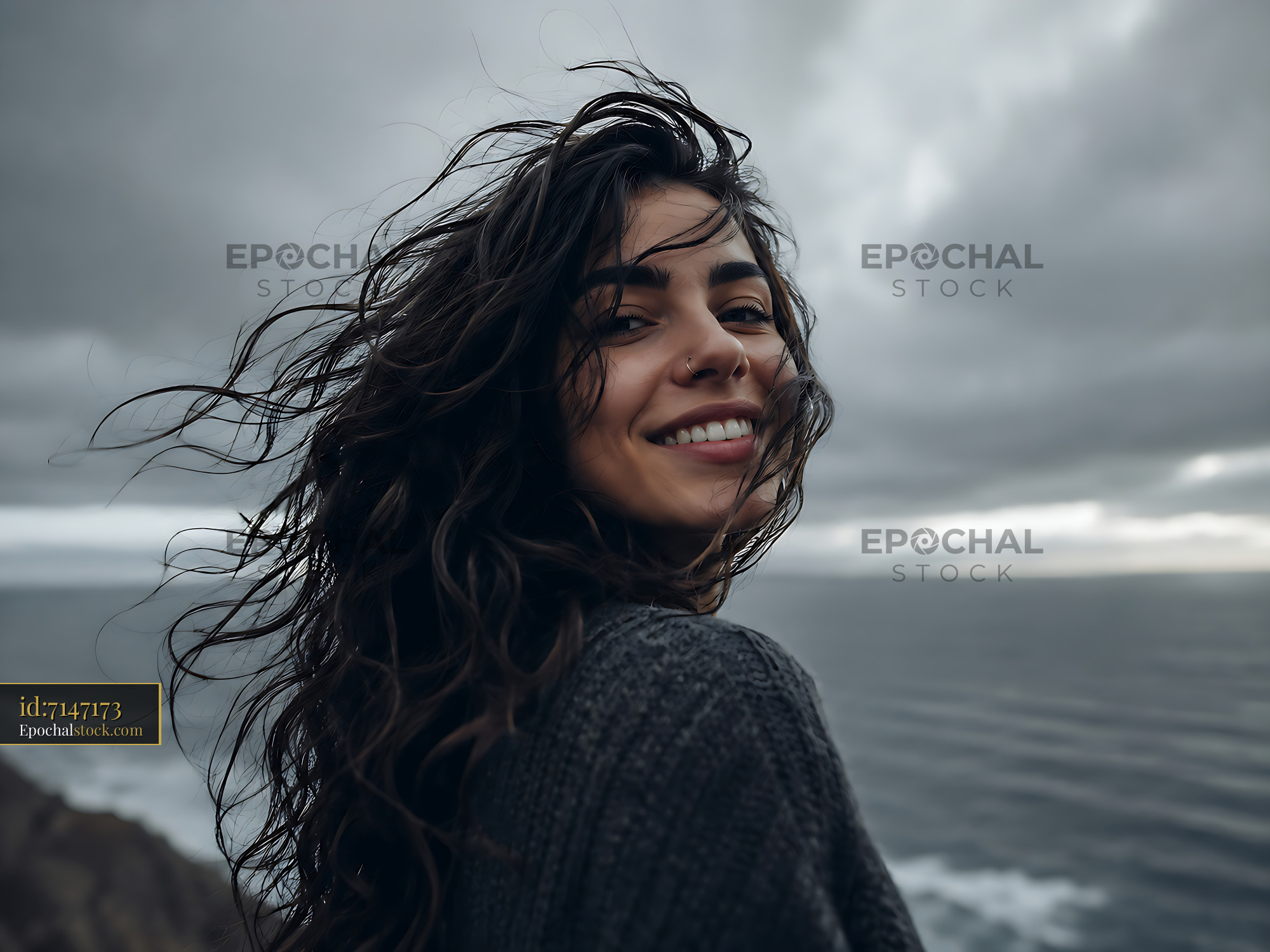 Watermarked full-resolution preview of Woman smiling with ocean view on a cloudy day