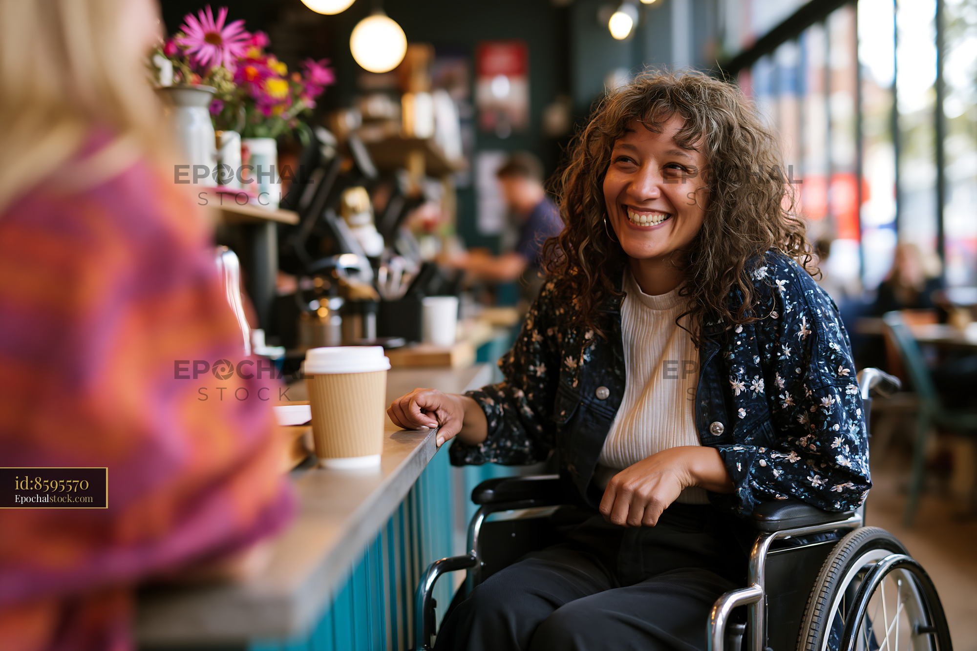 Watermarked full-resolution preview of Woman in wheelchair smiling at friend in coffee shop