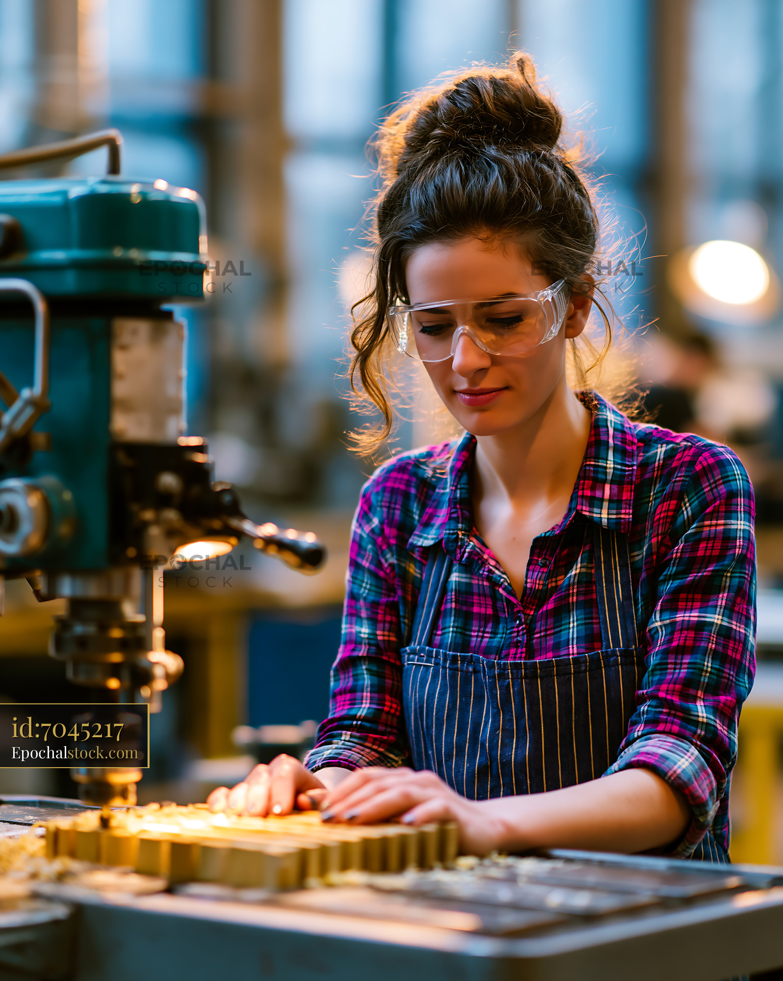 Watermarked full-resolution preview of Woman working with machinery in a workshop setting