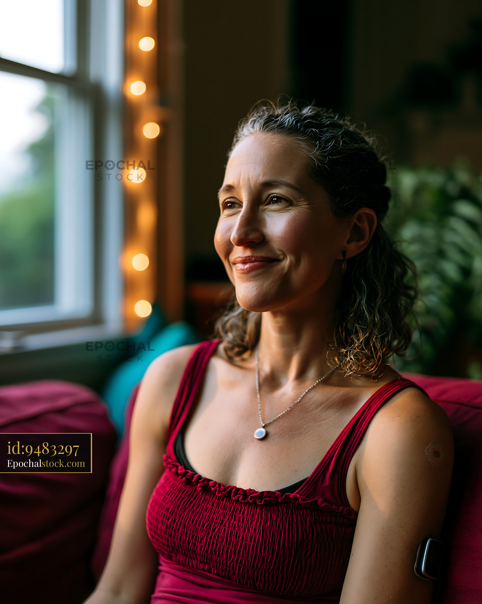Watermarked full-resolution preview of Woman sitting by a window with soft lighting in a cozy room