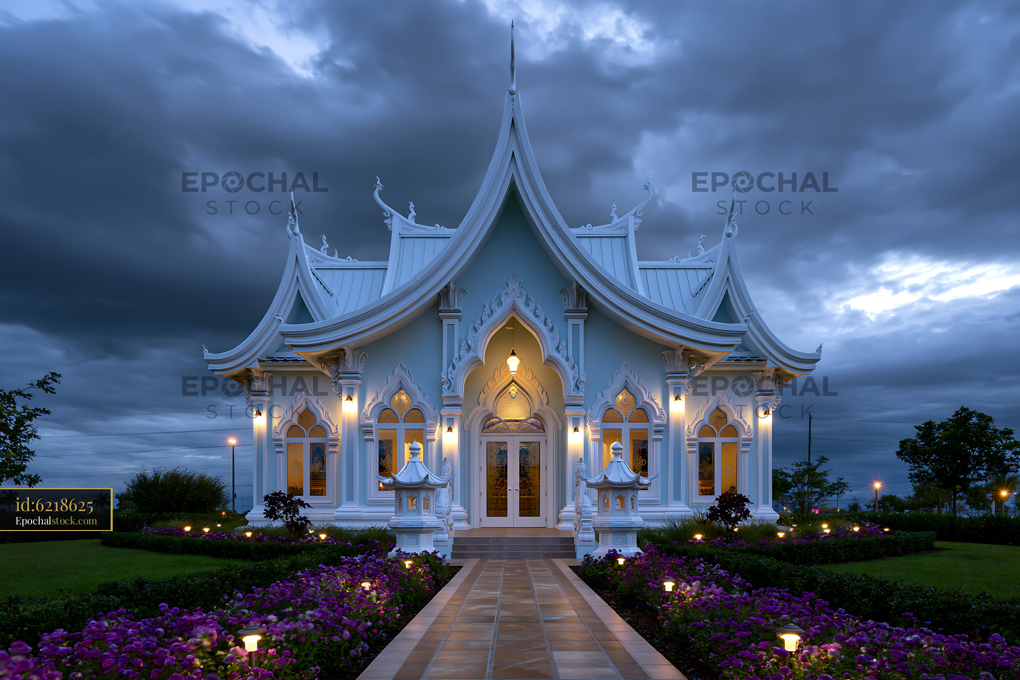 Watermarked full-resolution preview of Beautiful temple building at dusk with lit pathway and flowers