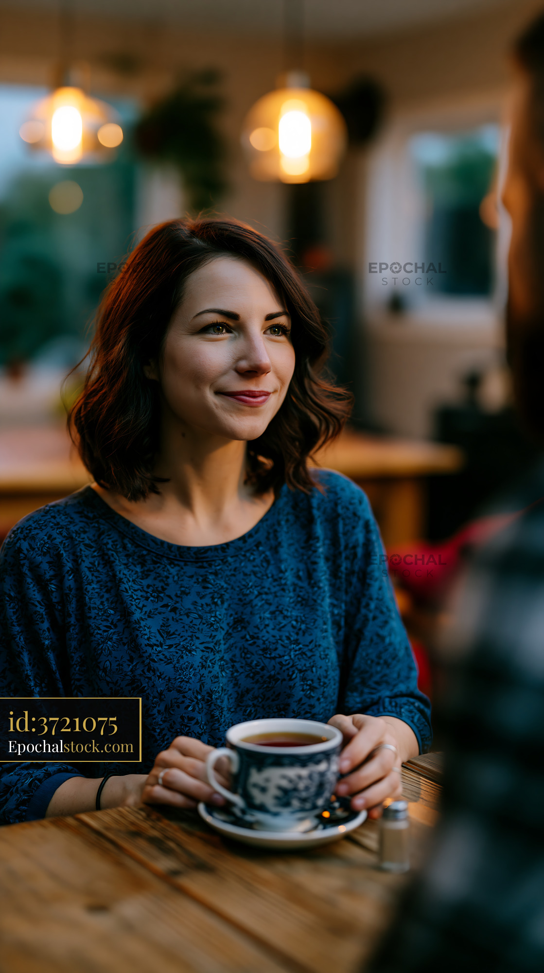 Watermarked full-resolution preview of Woman enjoying coffee in a cozy cafe