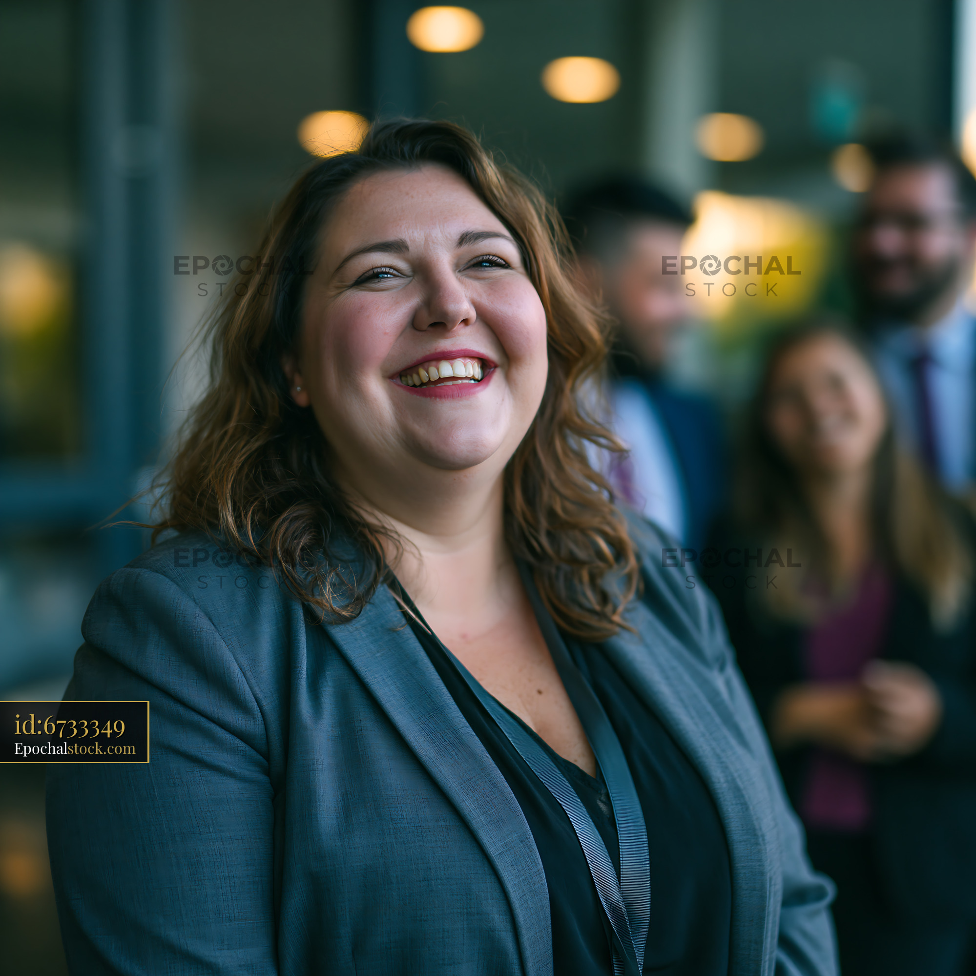 Watermarked full-resolution preview of Woman in business attire smiling with colleagues in office setting