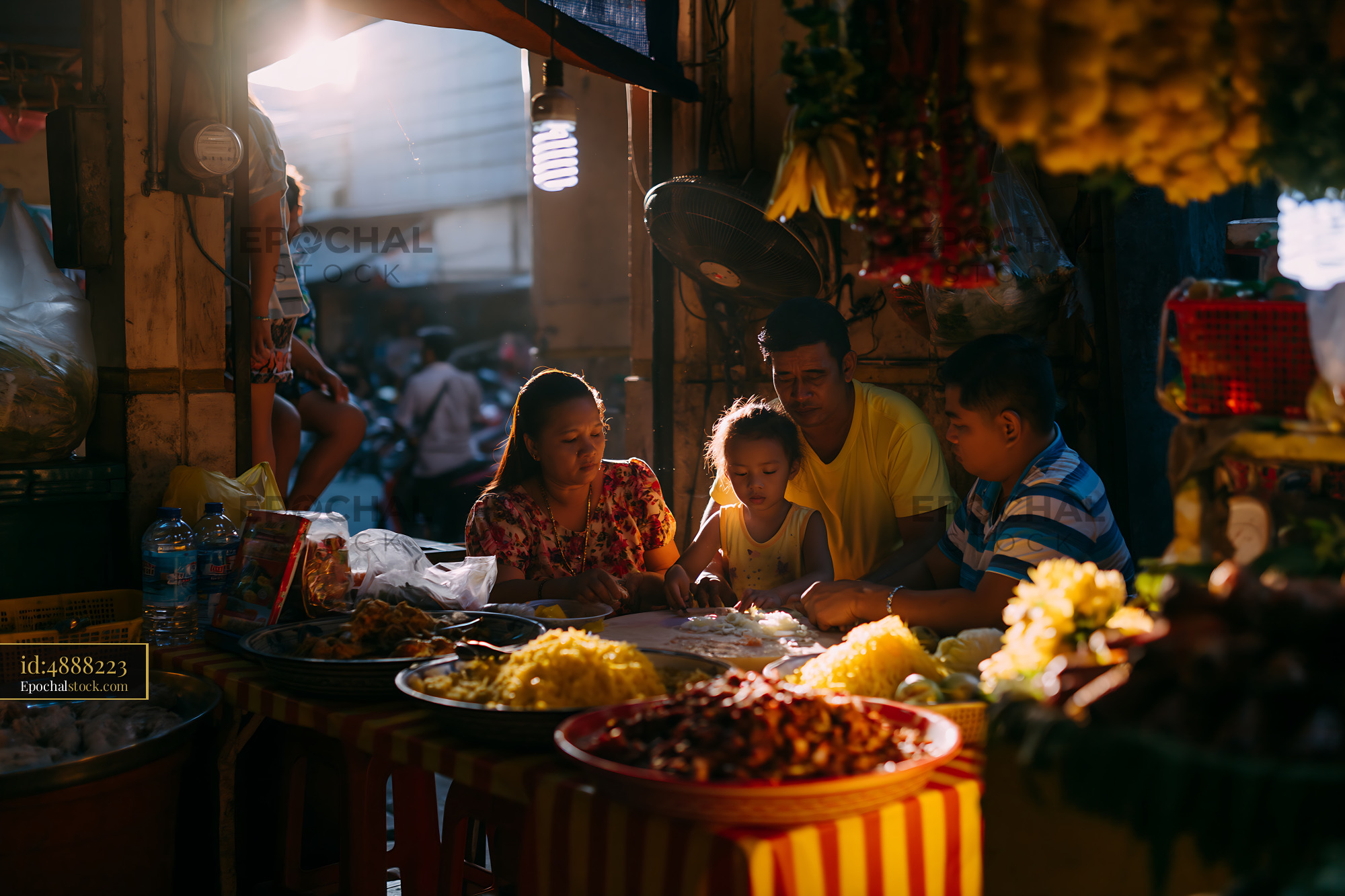 Watermarked full-resolution preview of Family enjoying a meal at a street market in evening light