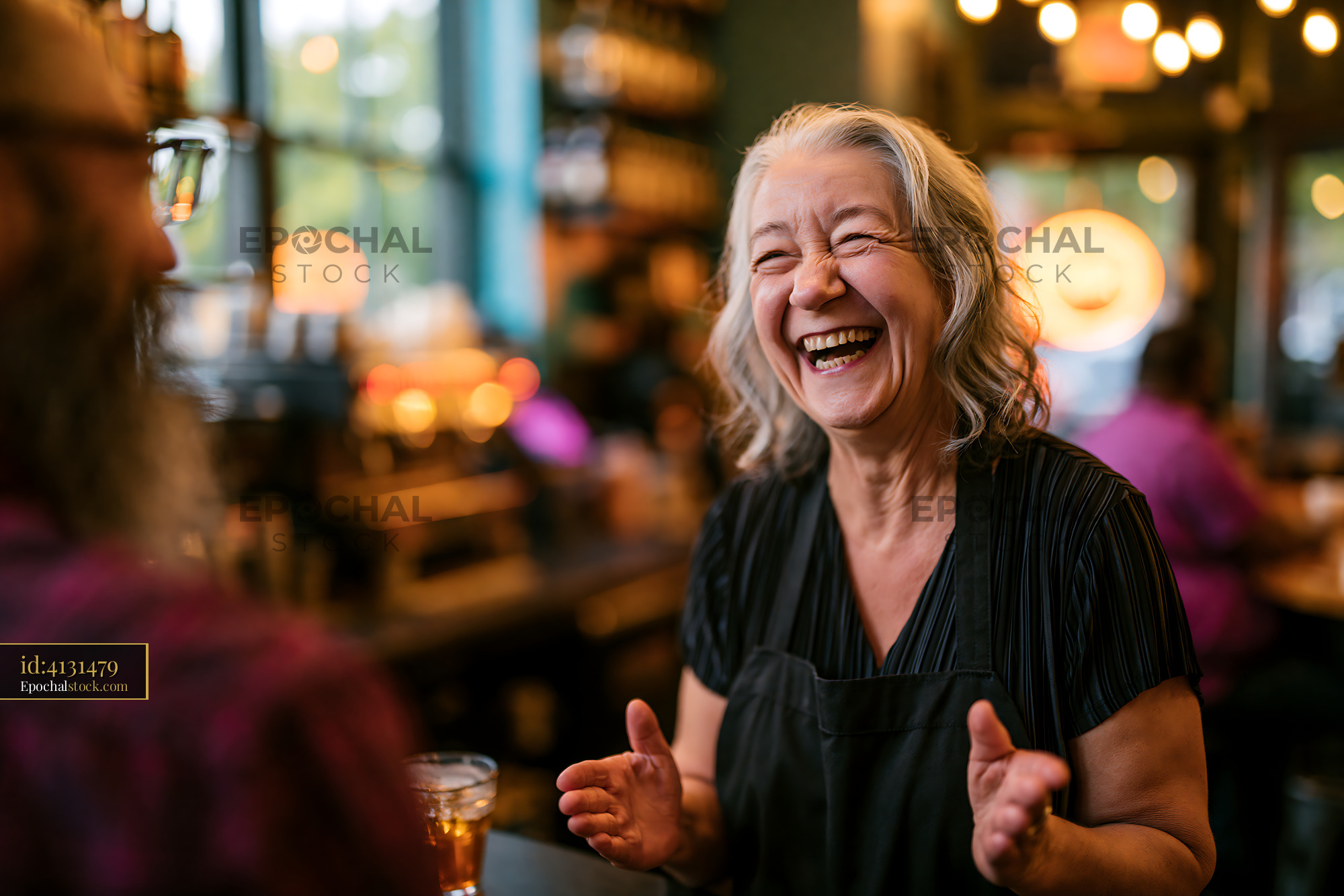 Watermarked full-resolution preview of Joyful interaction between a waitress and a customer in a cafe
