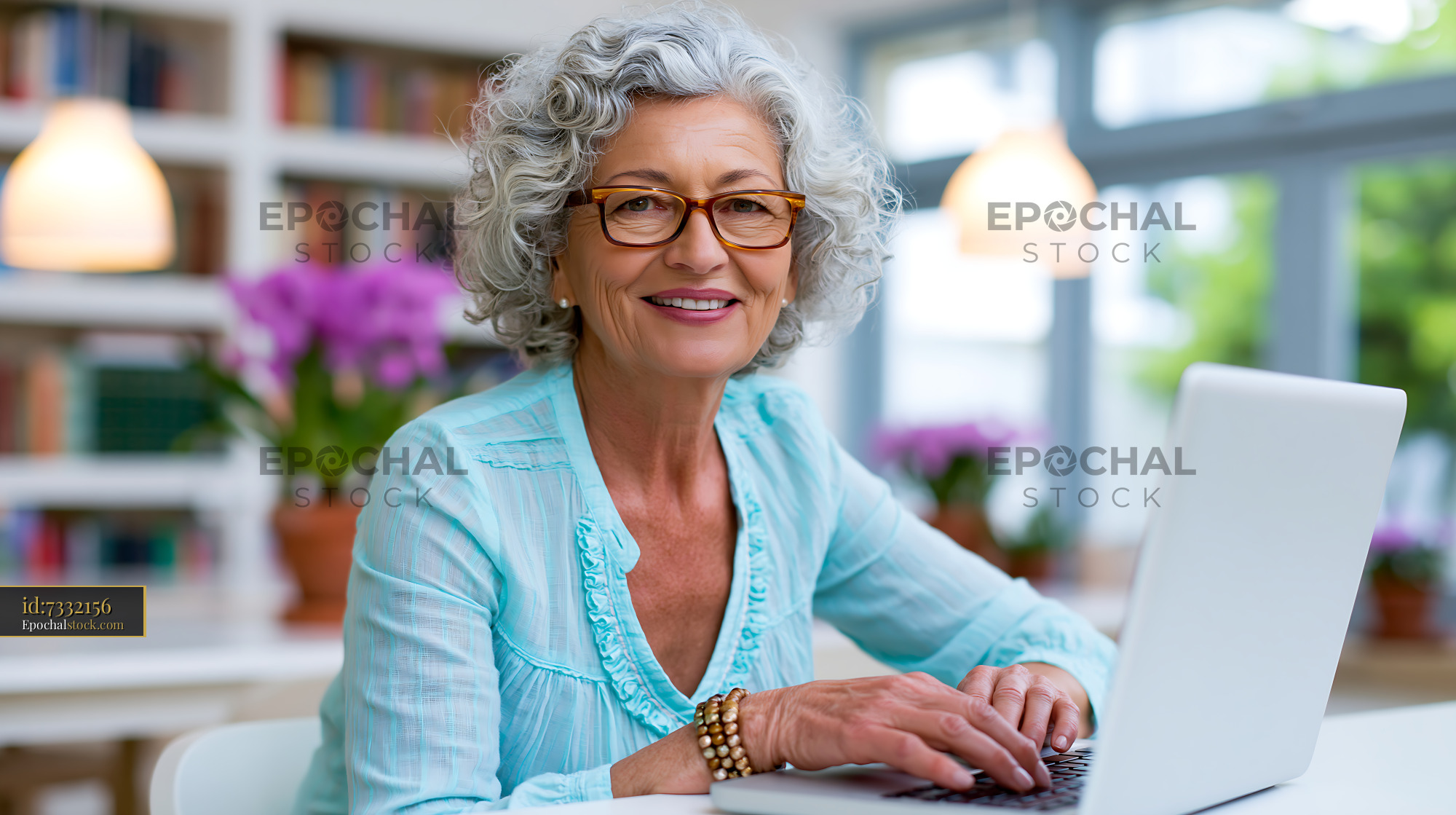 Watermarked full-resolution preview of Senior woman working on laptop in cozy indoor setting