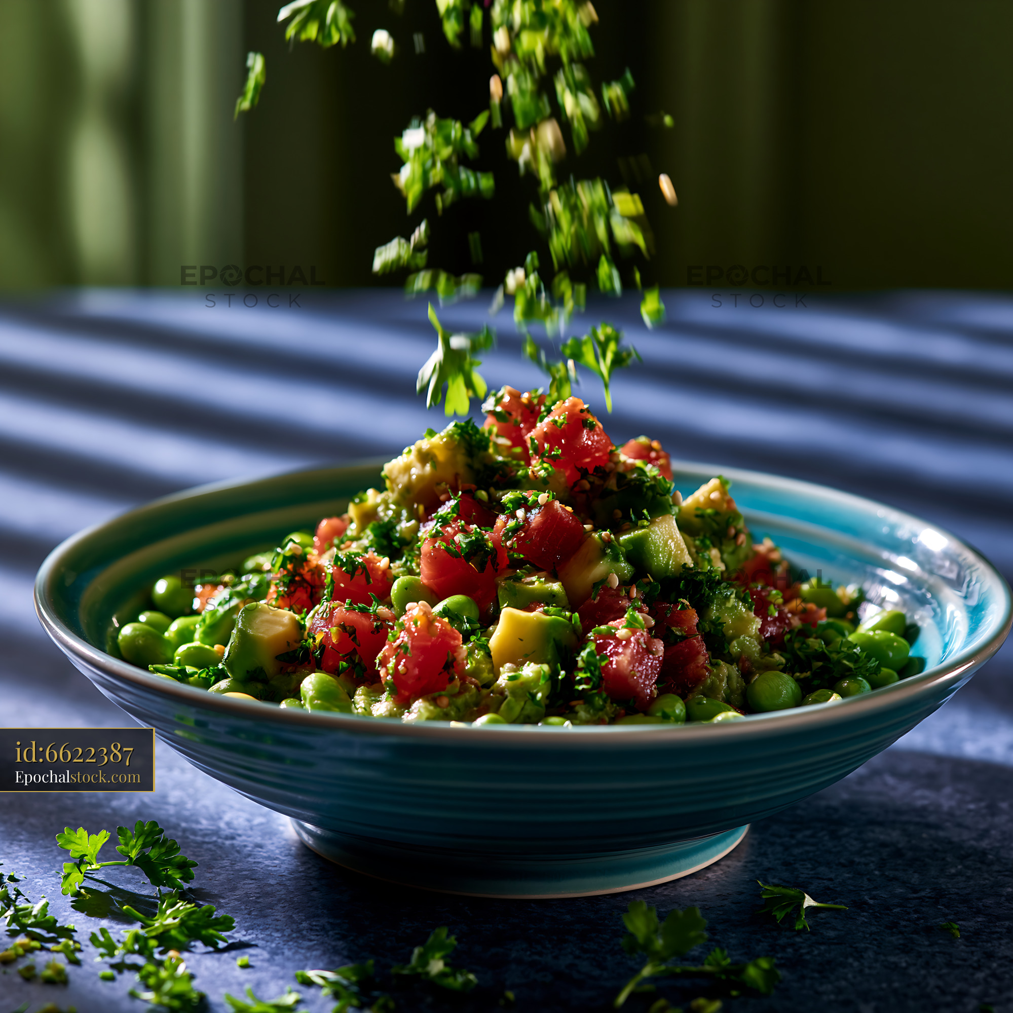 Watermarked full-resolution preview of Colorful avocado and tomato salad in blue bowl