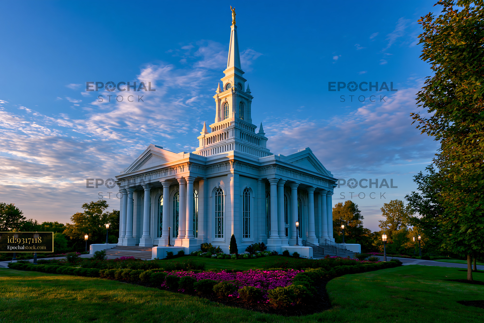 Watermarked full-resolution preview of Historic building with tall spire and surrounding gardens at sunset