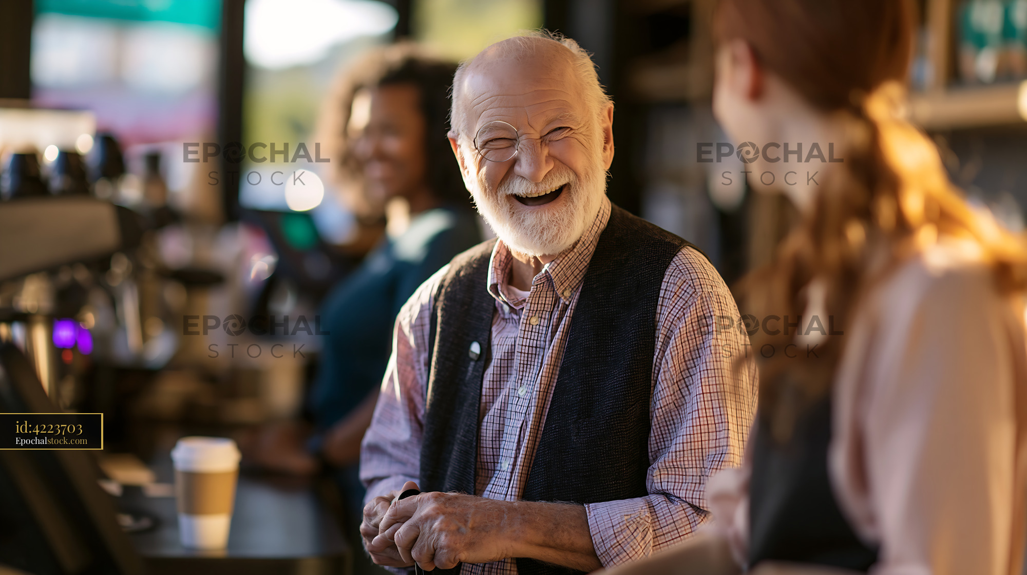 Watermarked full-resolution preview of Senior man smiling while talking to a barista in a cafe