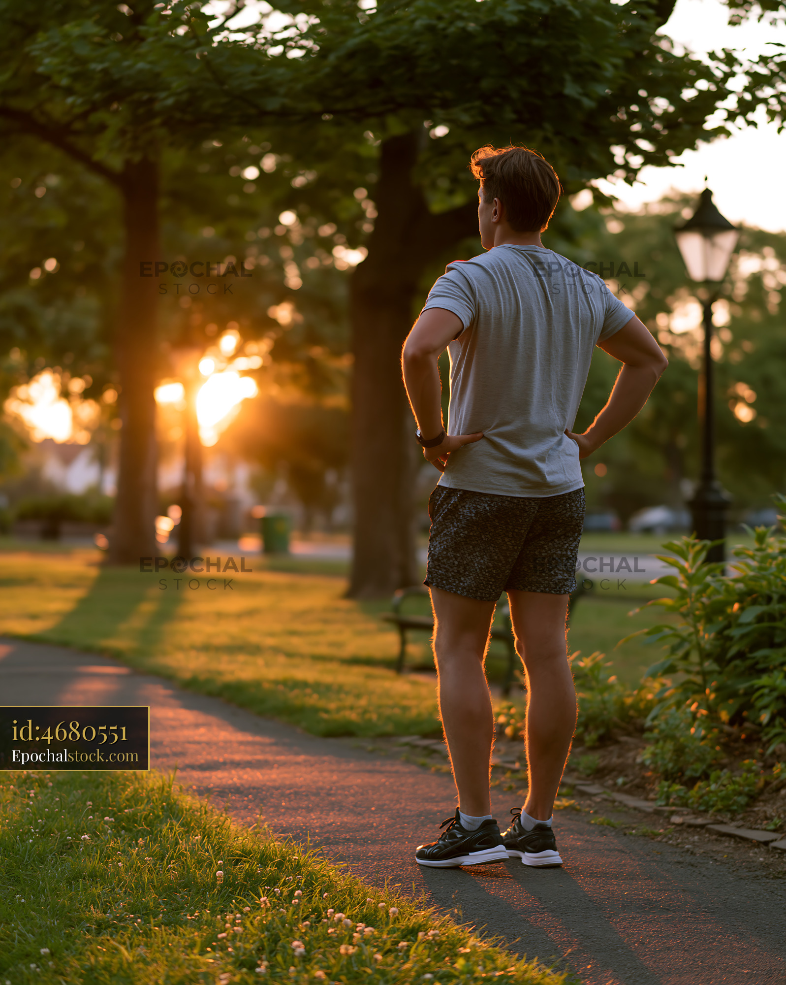 Watermarked full-resolution preview of Runner watching sunset in park during evening