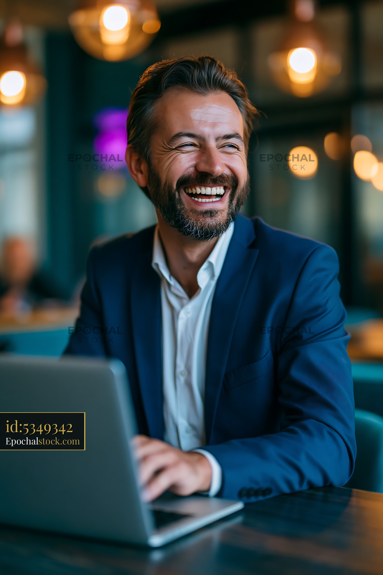 Watermarked full-resolution preview of Businessman working on laptop in urban cafe