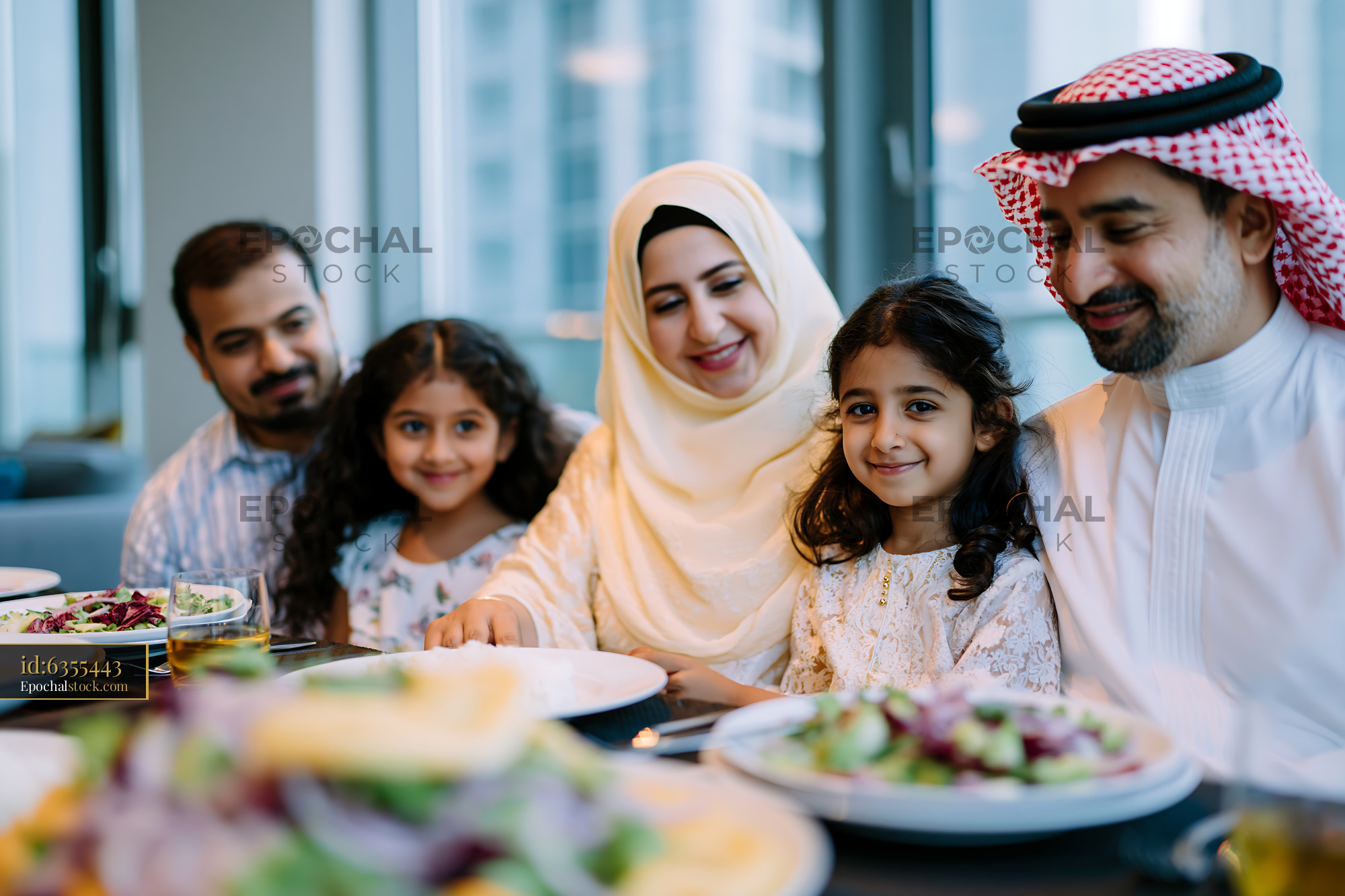 Watermarked full-resolution preview of Family enjoying a meal together in a modern dining setting