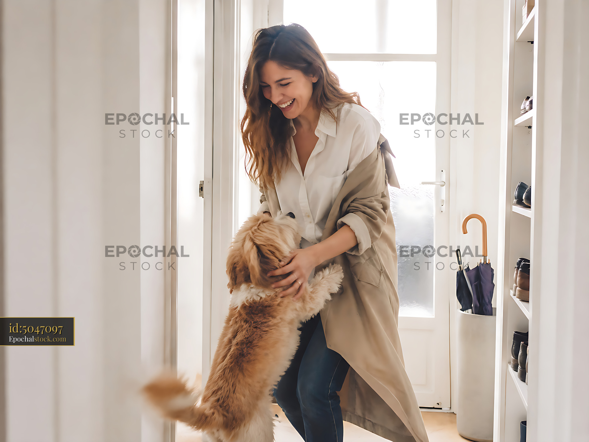 Watermarked full-resolution preview of Woman playing with dog in a bright hallway