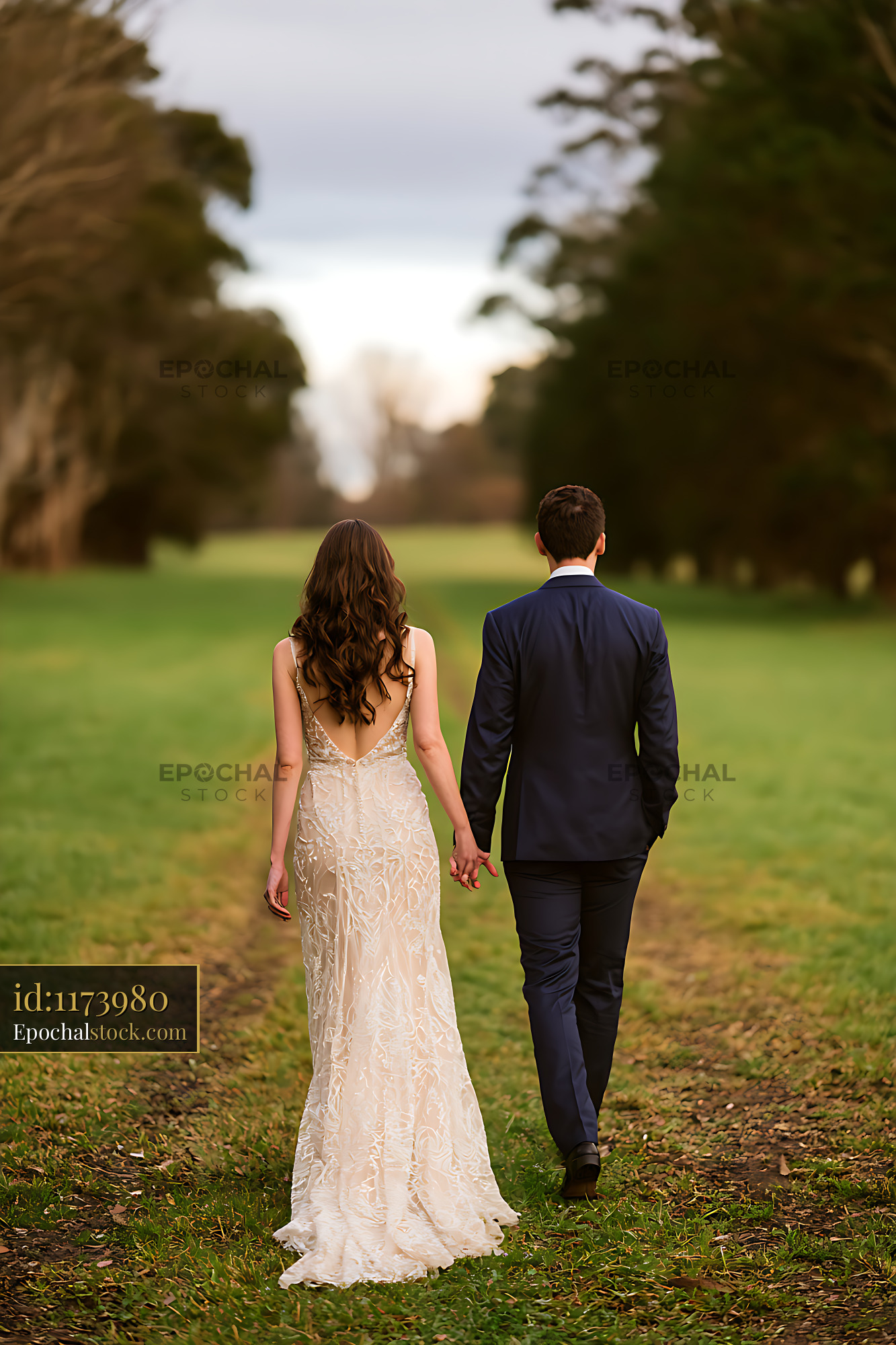 Watermarked full-resolution preview of Wedding couple walking together across a green park