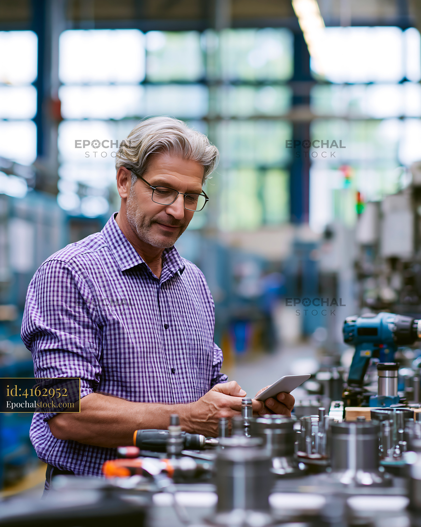 Watermarked full-resolution preview of Man reviews data in factory workshop