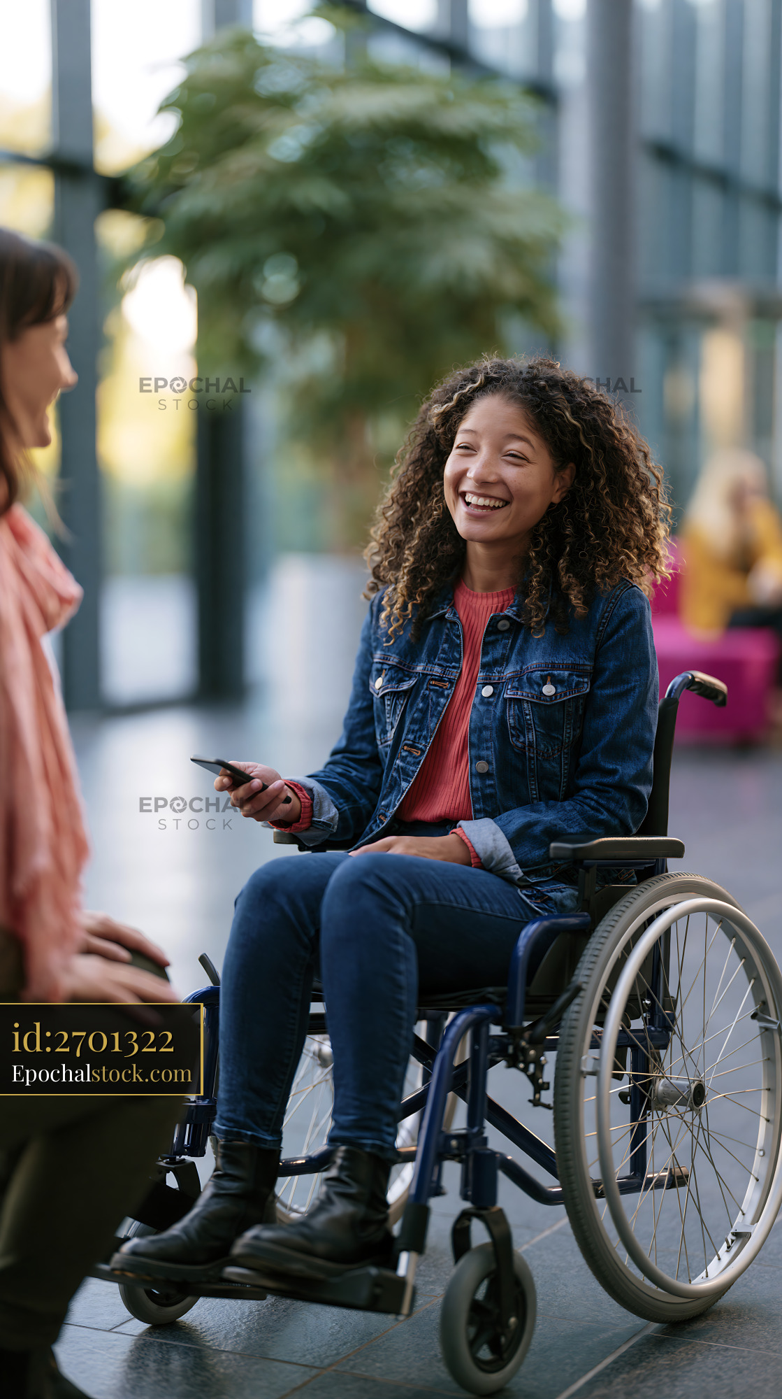 Watermarked full-resolution preview of Woman in wheelchair smiles during conversation indoors