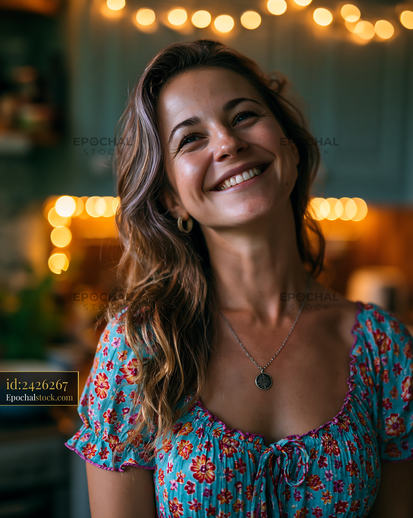 Watermarked full-resolution preview of Smiling woman in a kitchen with string lights