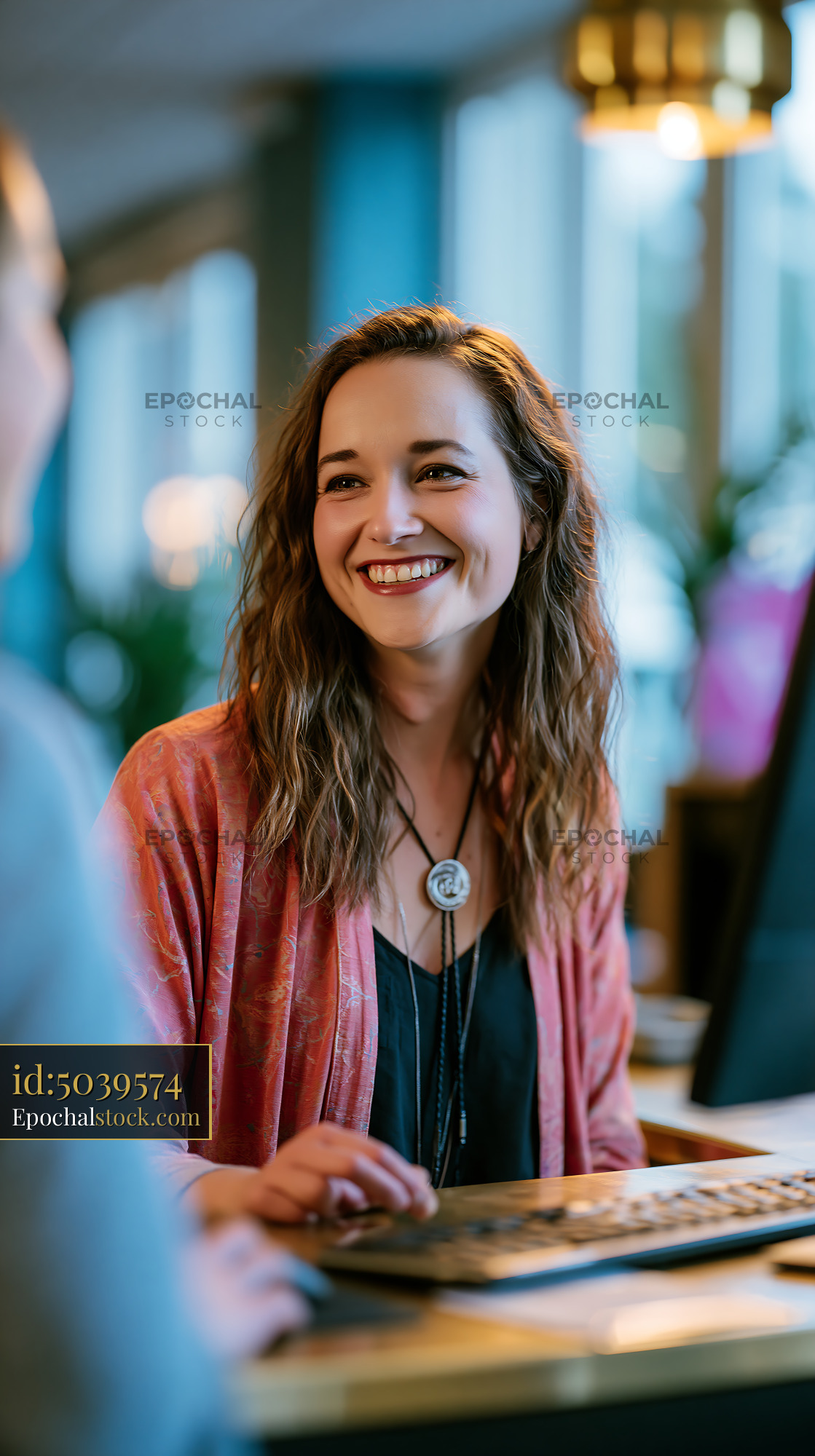 Watermarked full-resolution preview of Smiling woman at a counter in a modern cafe