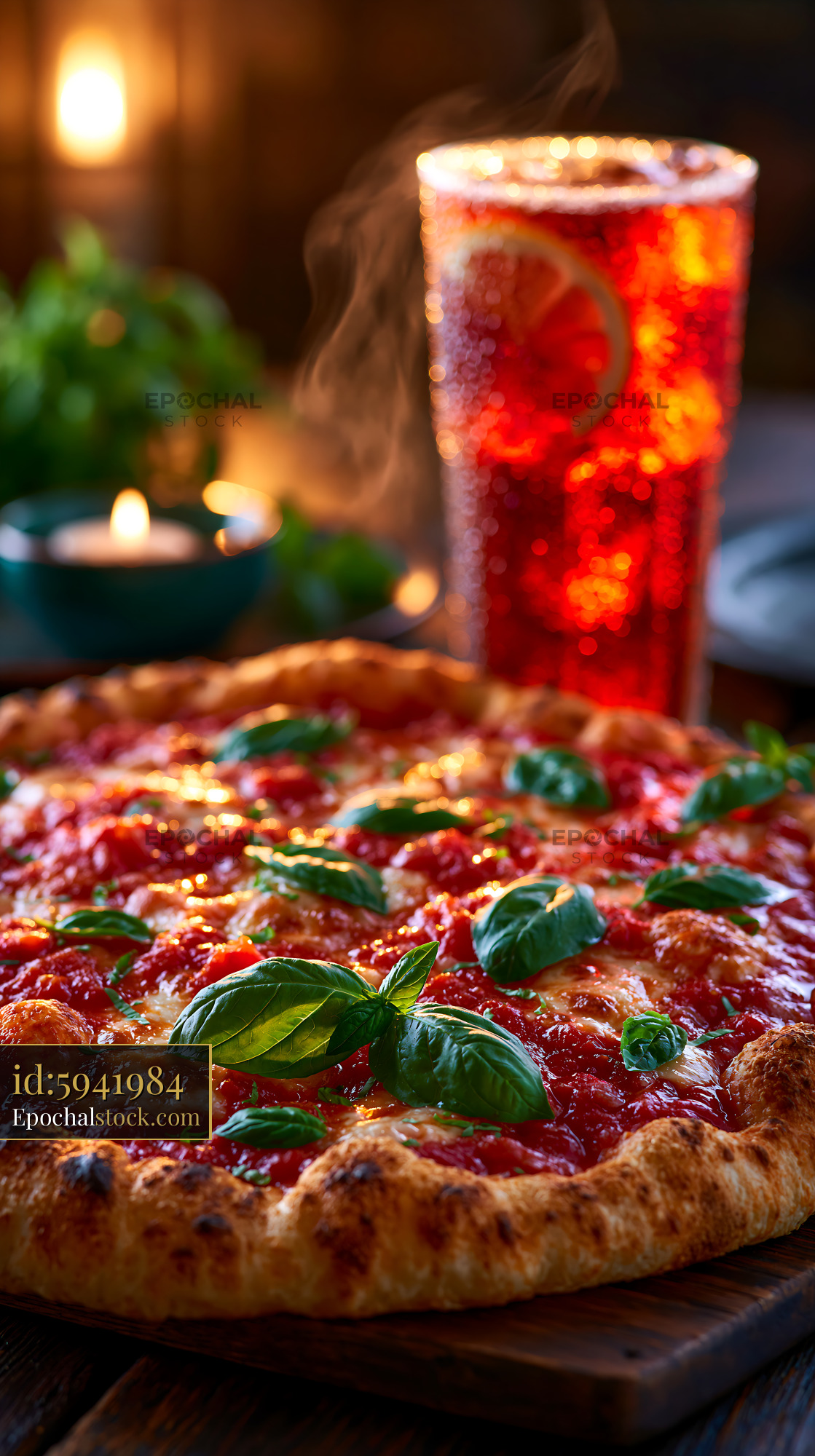 Watermarked full-resolution preview of Freshly baked pizza with basil and a cold drink on the table