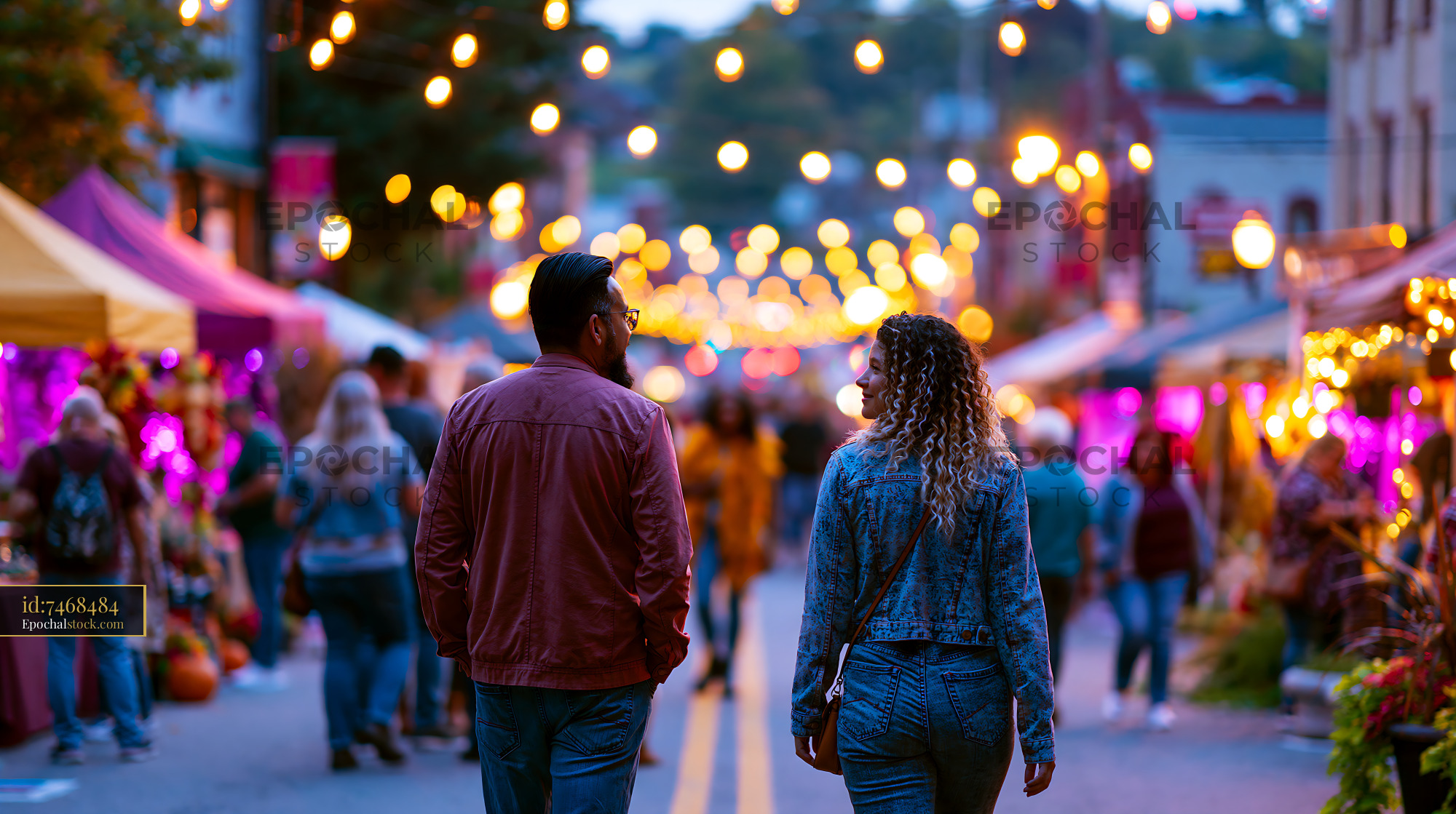 Watermarked full-resolution preview of Couple walking through festive street market at night