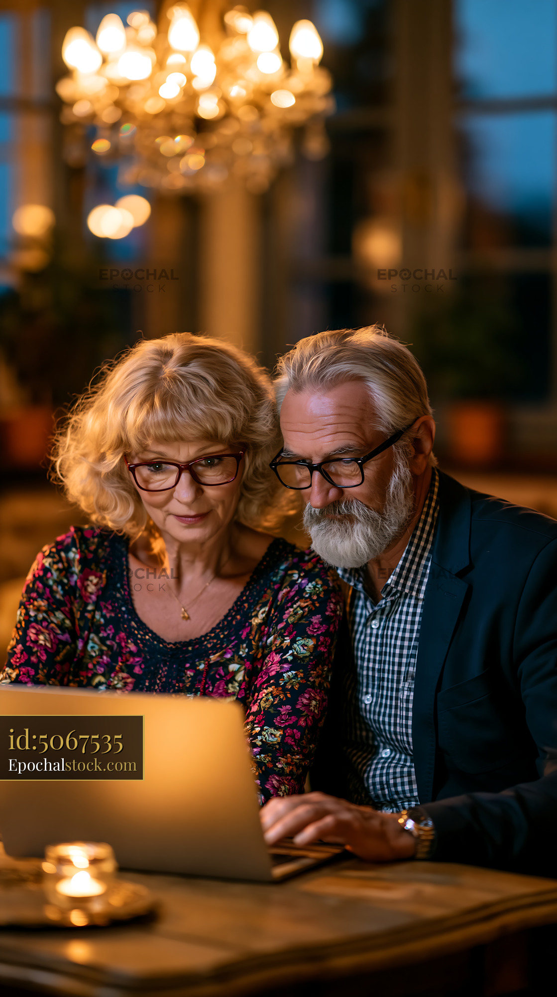Watermarked full-resolution preview of Couple working together on a laptop in a cozy evening setting