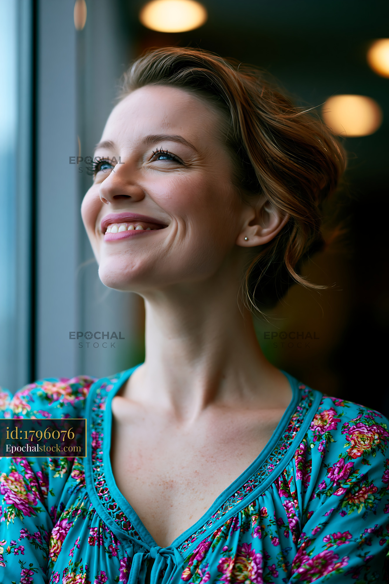 Watermarked full-resolution preview of Woman looking out window with a smile
