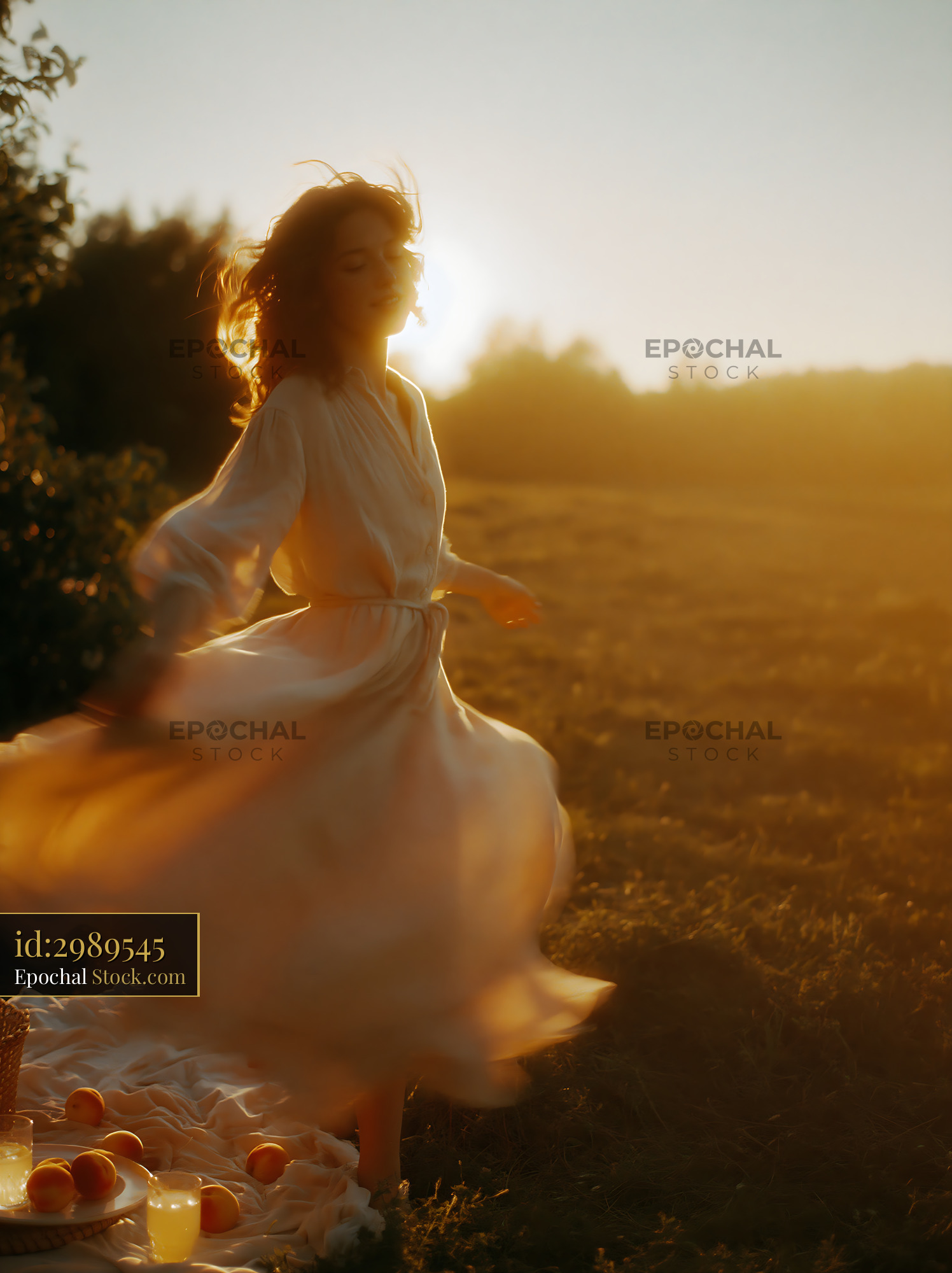 Young woman in white dress dancing in a meadow at sunset - stock photo
