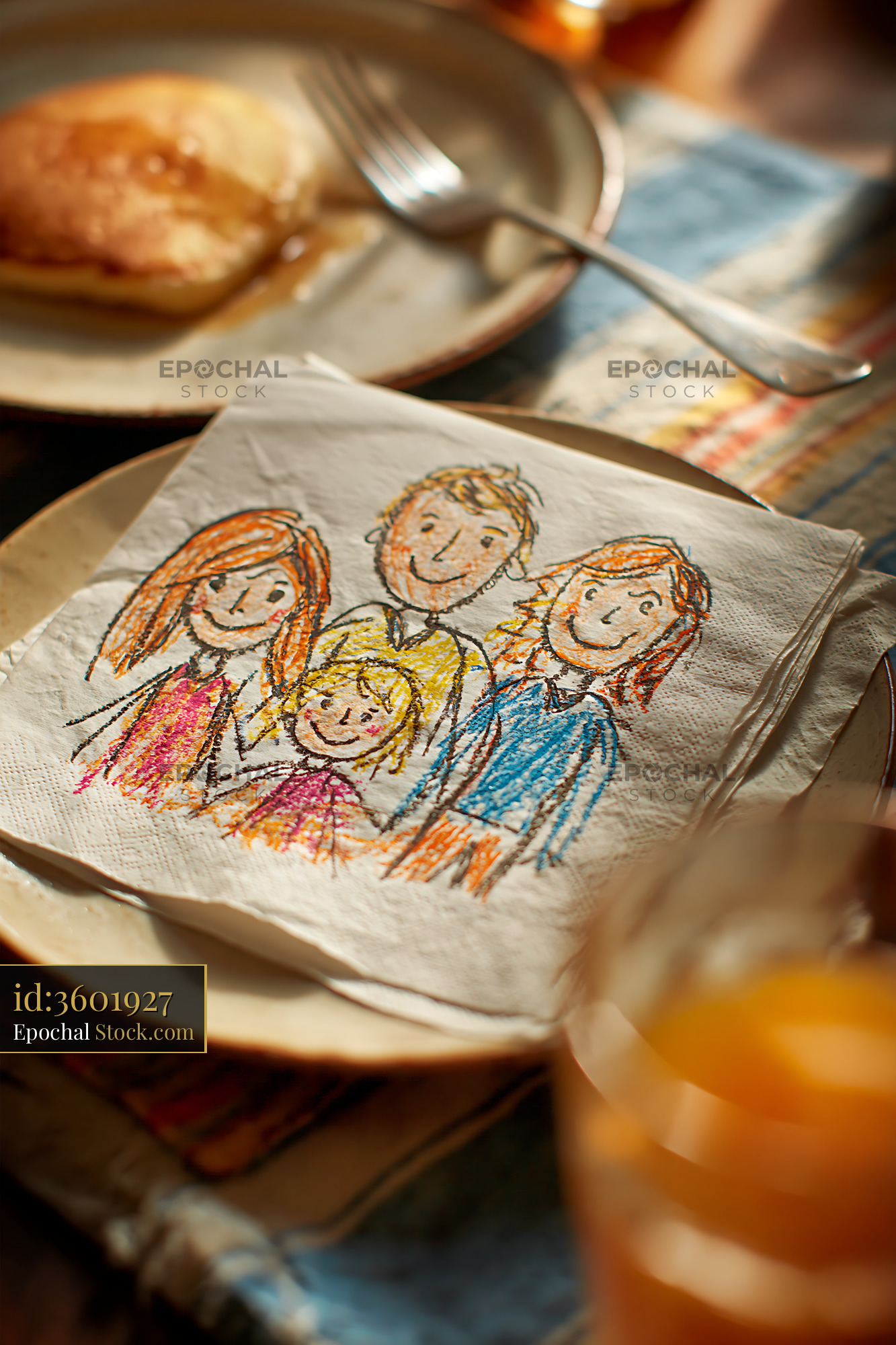 Child's colorful drawing of a family on a napkin at breakfast table